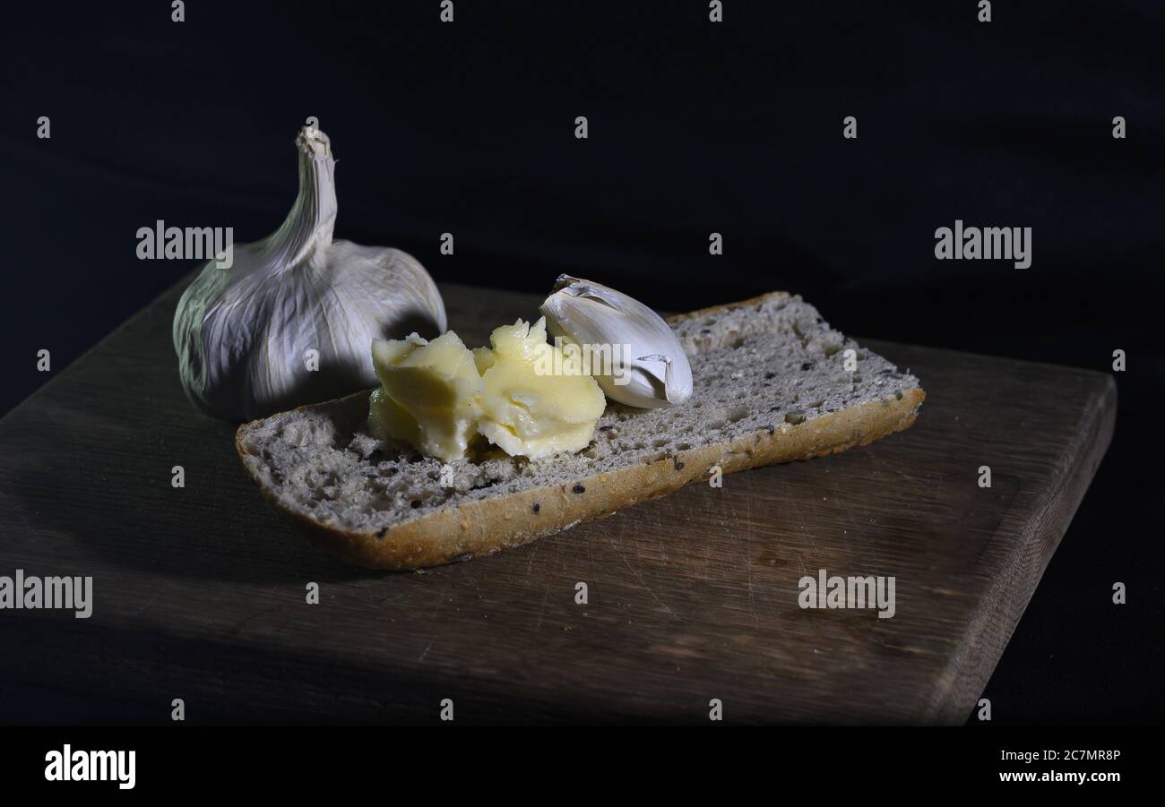 Closeup shot of garlic bread ingredients - bread, butter and garlic on the table Stock Photo
