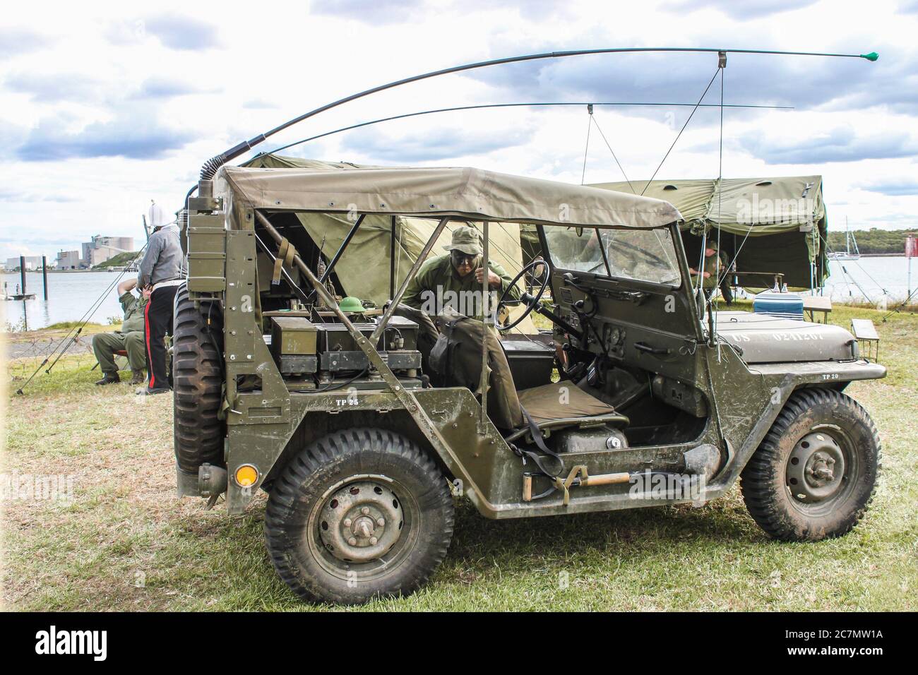 May 09 2014 Brisbane Australia  Living History reenactment - WW2 Jeep with antennas tied down and shovel secured to side - man in army uniform with pa Stock Photo