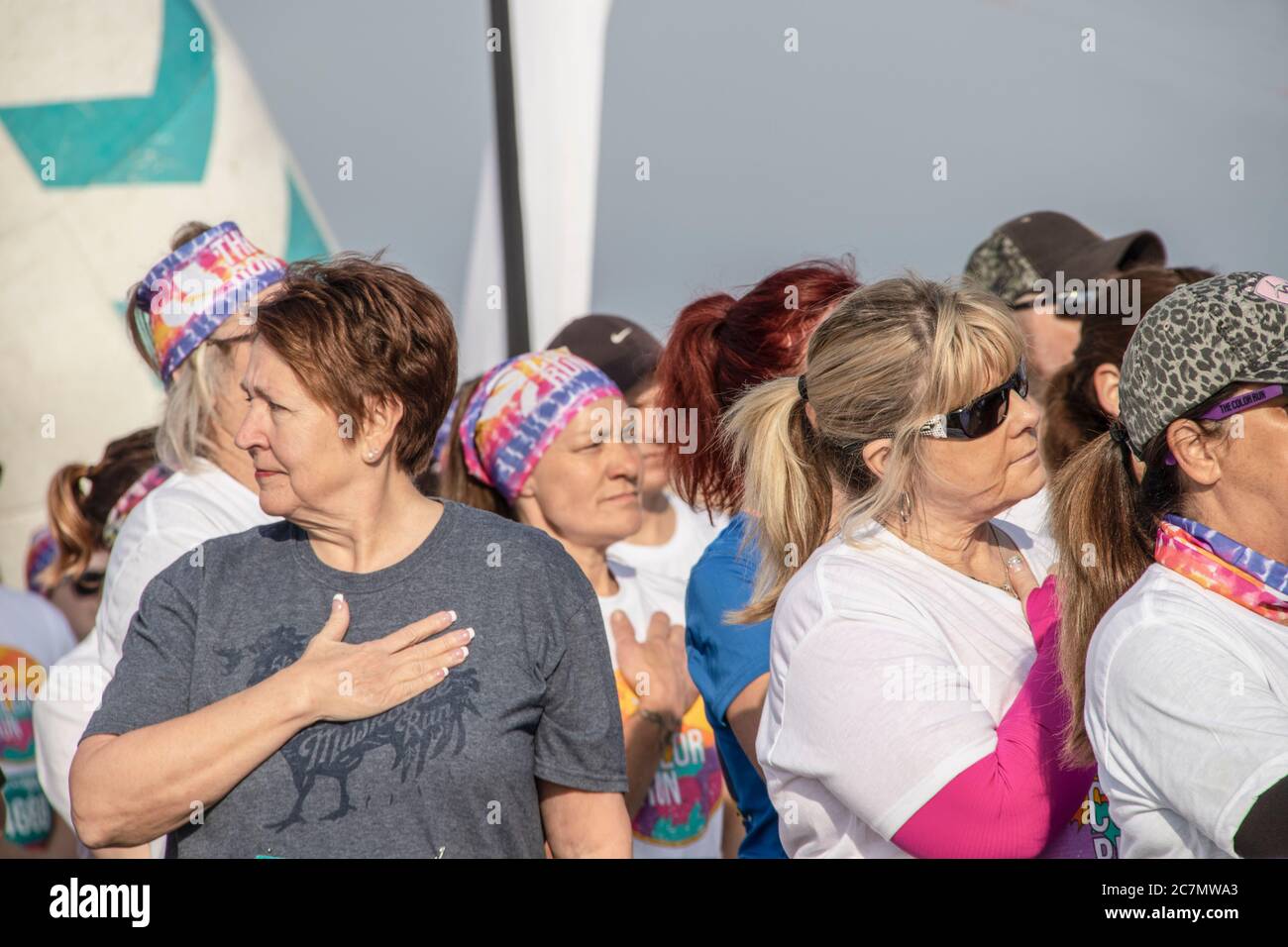 April 6 2019 Tulsa USA People in line for Color run put hands over their hearts for National Anthem Stock Photo