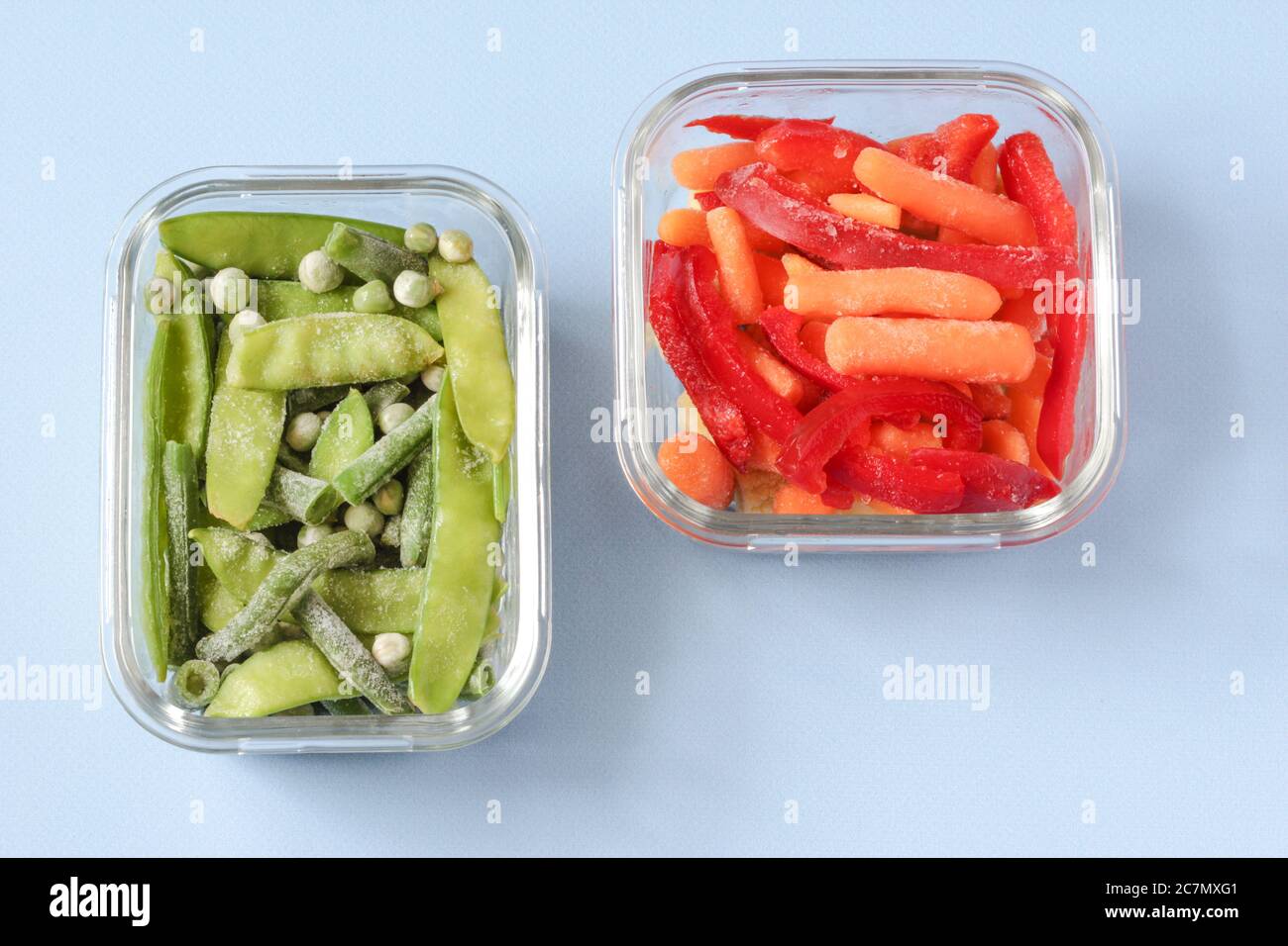 Frozen vegetables such as green peas, pea pods, green beans, red sweet pepper and baby carrot in the transparent bowls Stock Photo