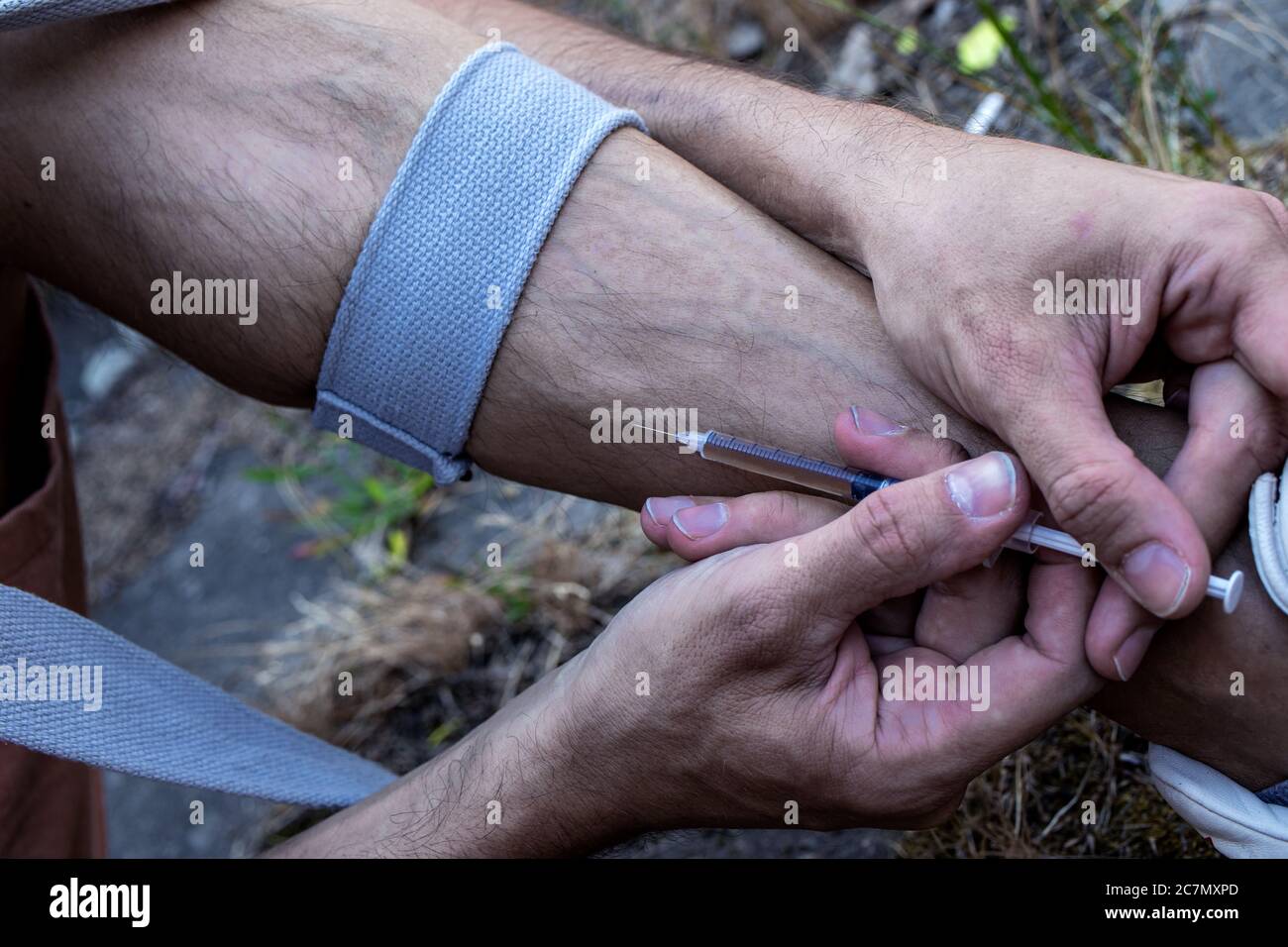Hands of a drug addict with a syringe full of narcotic, heroin or