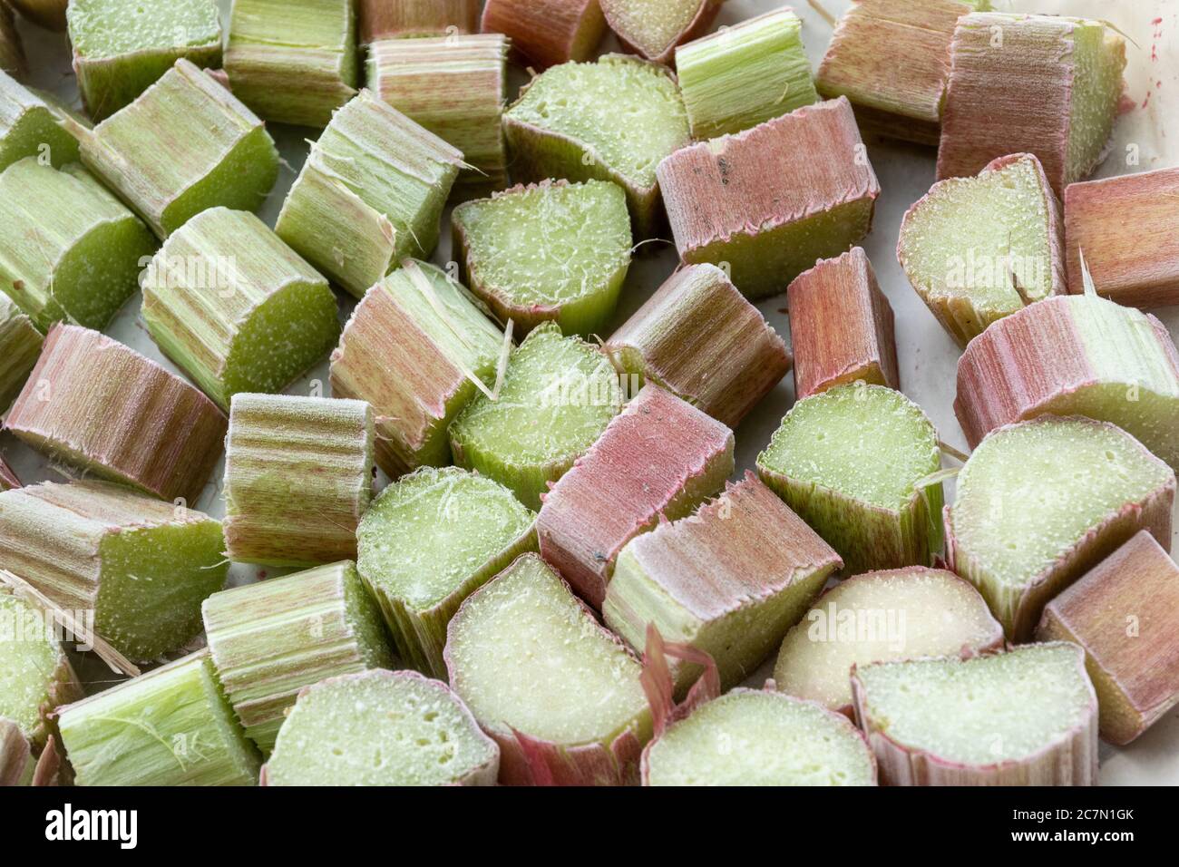 Chunks of rhubarb frozen in a single layer on a tray. Home freezing summer fruit. Stock Photo