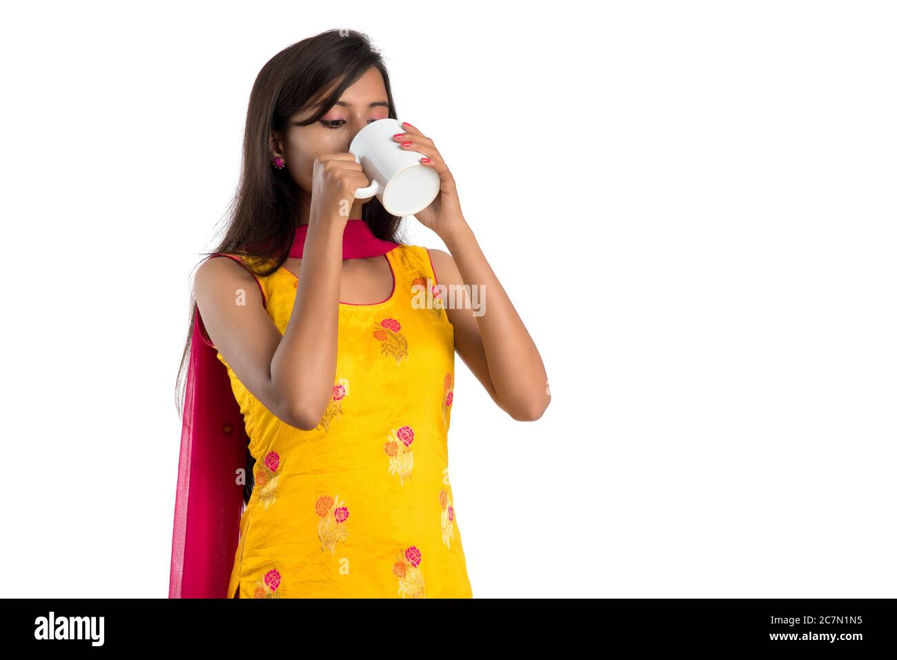 pretty young girl with cup of tea or coffee posing on white background ...
