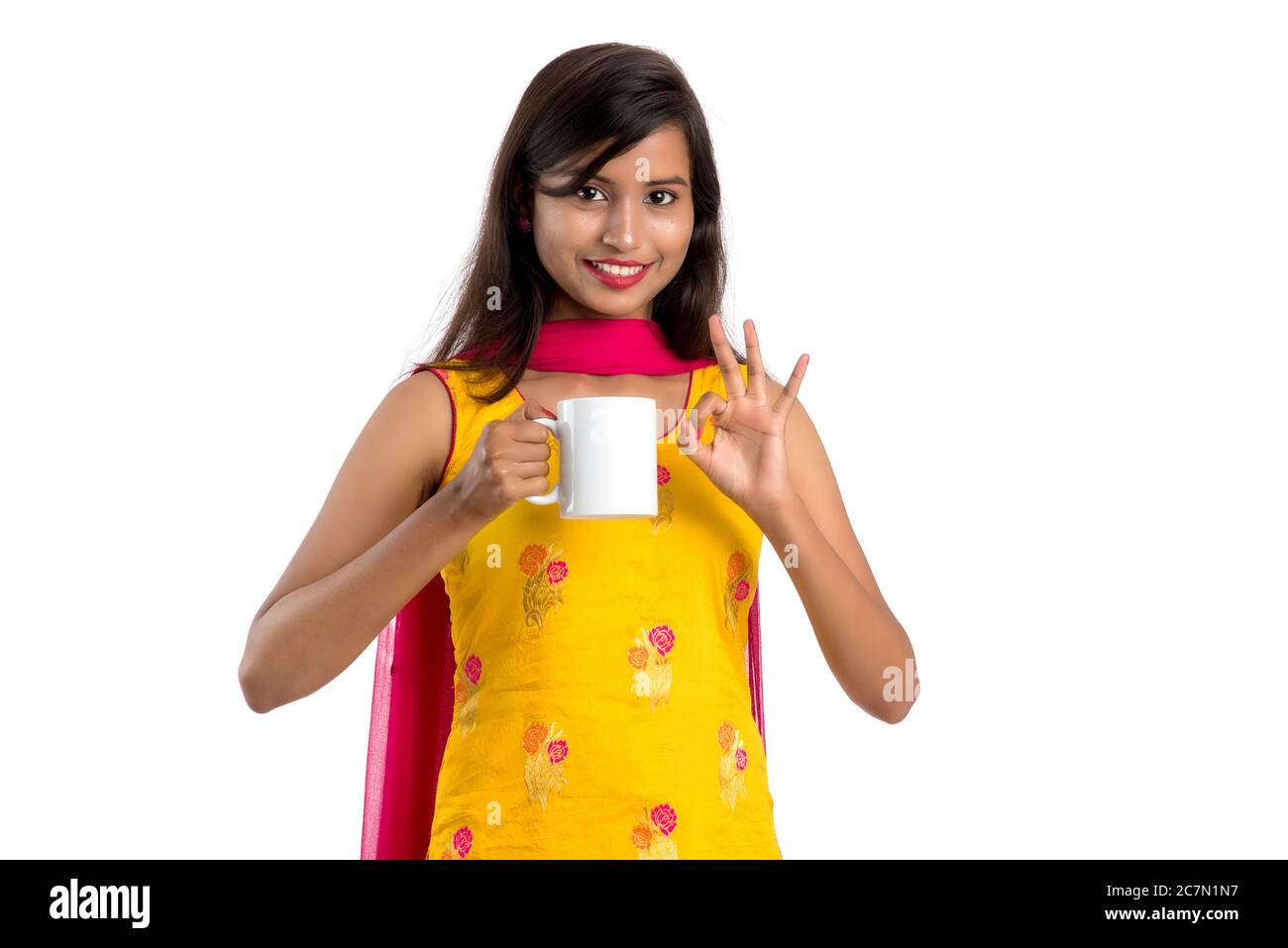 pretty young girl with cup of tea or coffee posing on white background ...