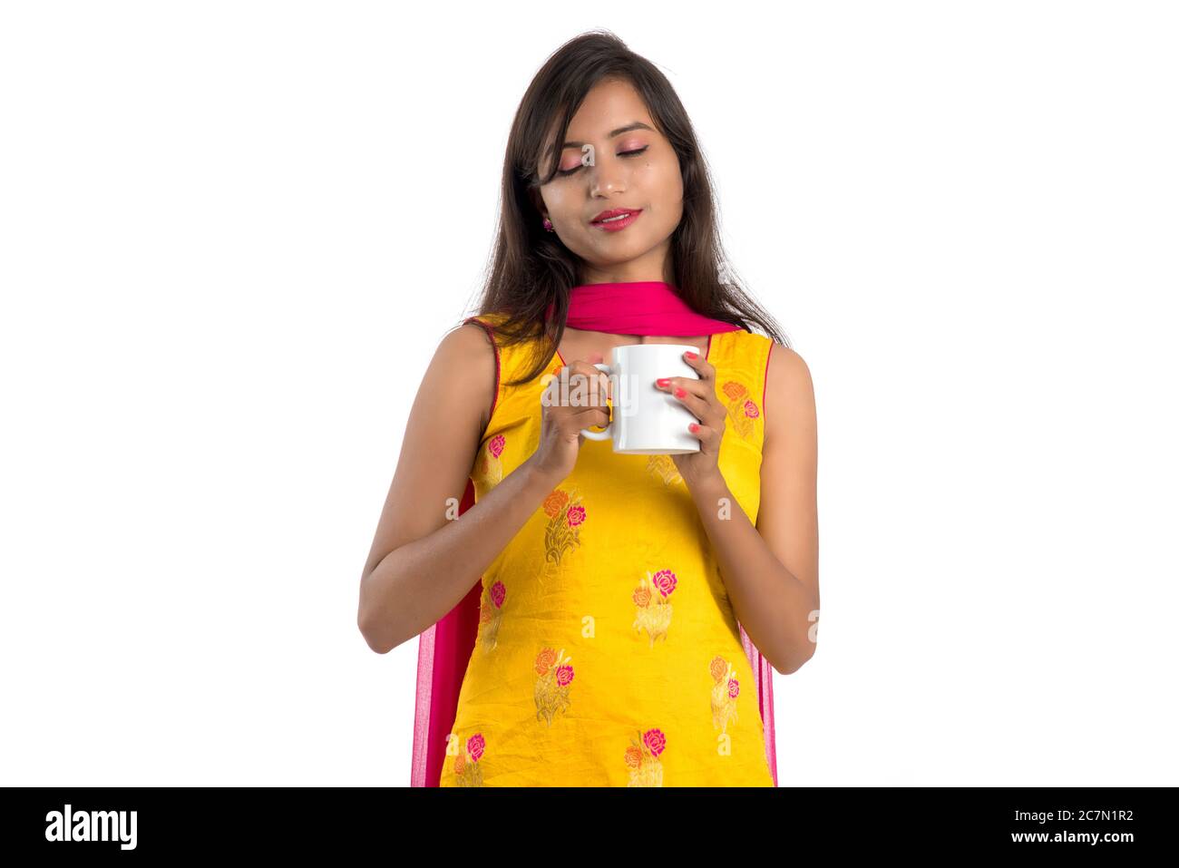pretty young girl with cup of tea or coffee posing on white background ...