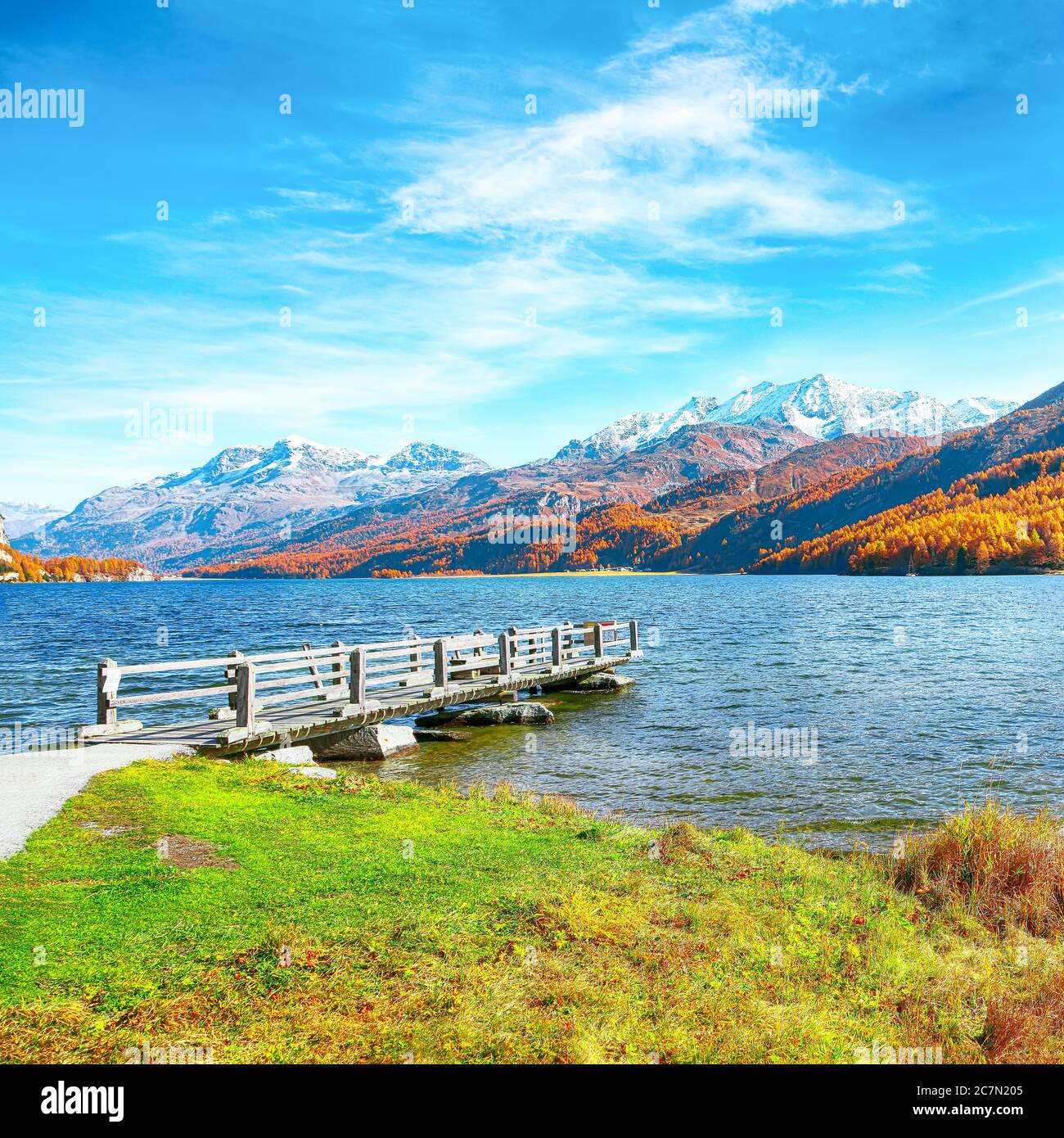 Wooden pier and fantastic view on Sils Lake (Silsersee). Colorful autumn scene of Swiss Alps. Location: Maloya, Engadine region, Grisons canton, Switz Stock Photo