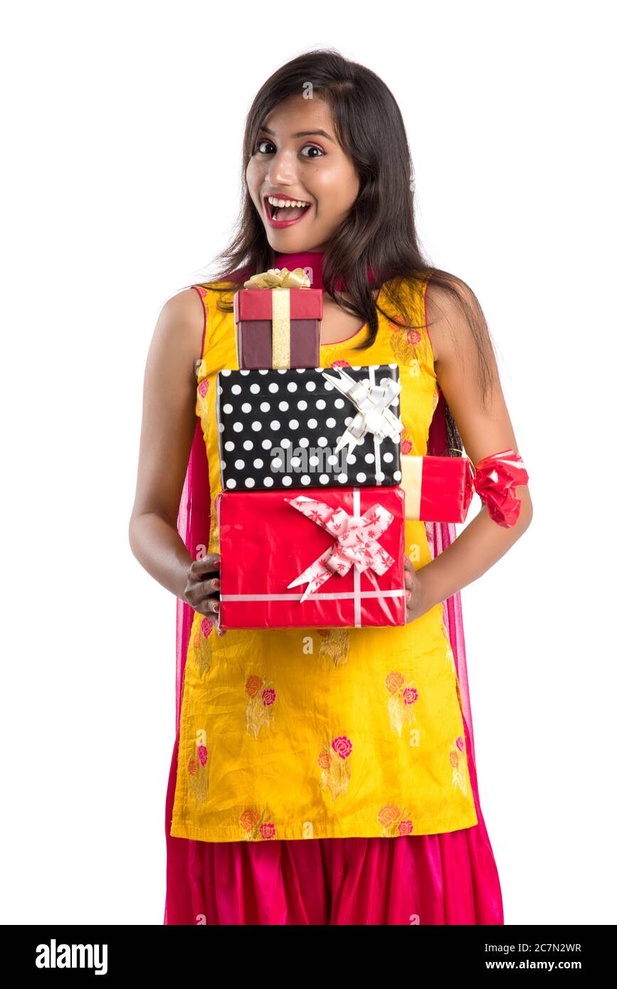 Portrait of young happy smiling Indian Girl holding gift boxes on a ...