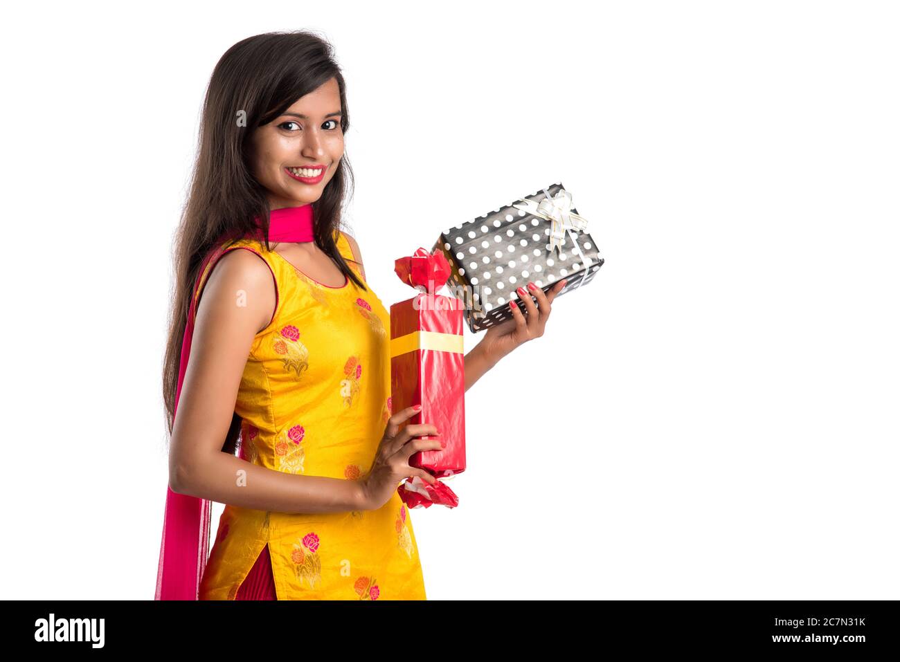 Portrait of young happy smiling Indian Girl holding gift boxes on a ...