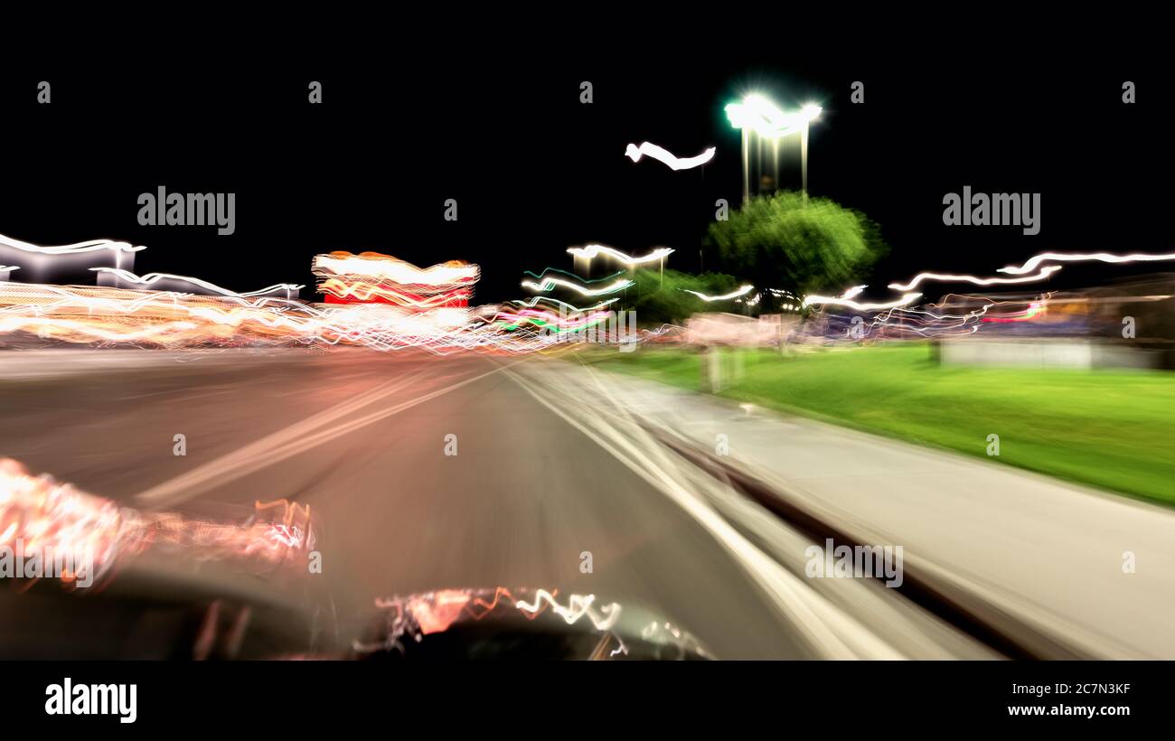 Wendover, Utah driving point of view in Nevada city hotels and casinos on road at night illuminated neon light trails abstract blurred motion backgrou Stock Photo