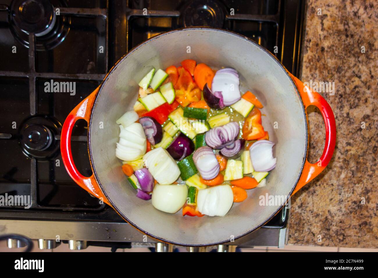 Colourful prepared vegetables in casserole pan cooking on a cooker gas