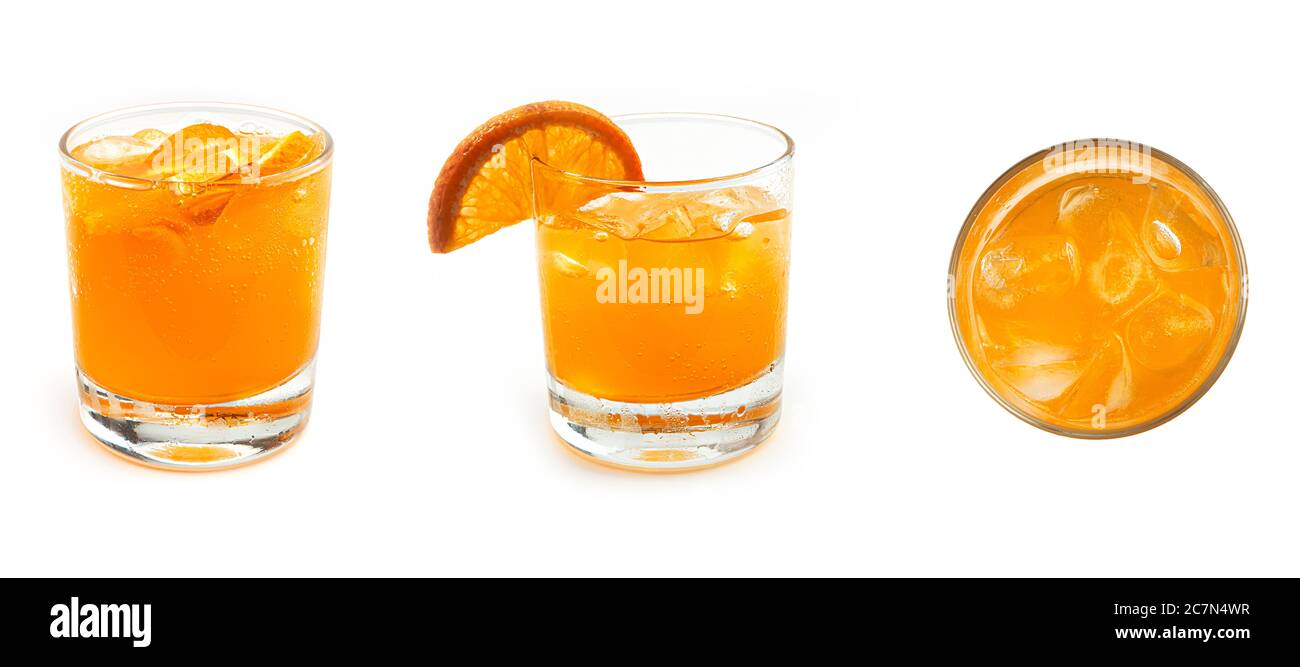 Orange lemonade with ice and slices of fresh orange in a transparent low glass on a white