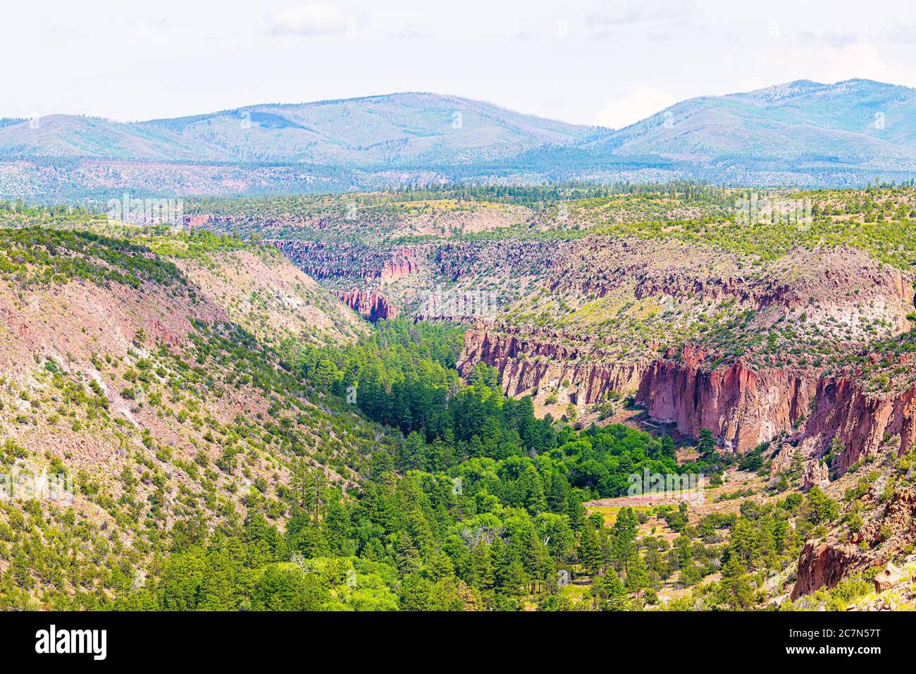 View of canyon overlook vista in Bandelier National Monument in New Mexico in Los Alamos during summer with Jemez mountains and rock formations Stock Photo