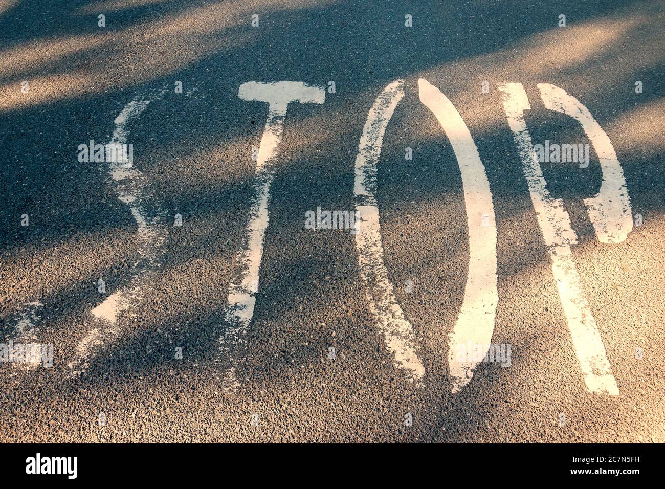 Stop word on asphalt. Warning mark written on highway ground. Traffic safety letters paint on road surface. Grunge text on transport floor.  conceptua Stock Photo