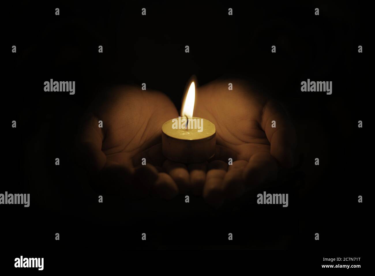 Closeup shot of a small candle in person's hands perfect for praying