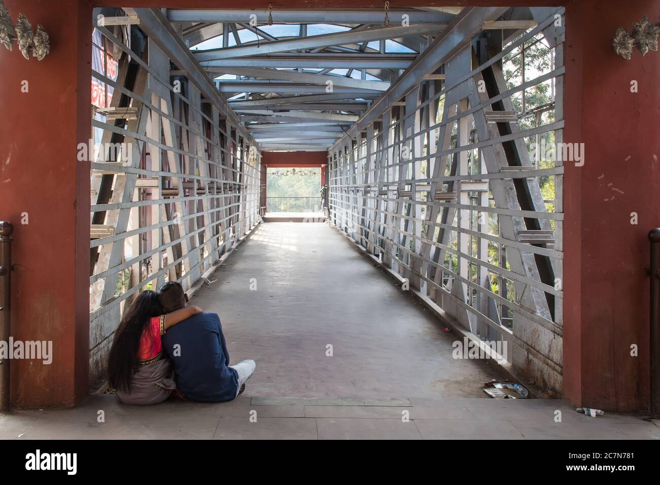 A young couple of 20-25 age enjoying a moment of silence at a walking bridge Stock Photo