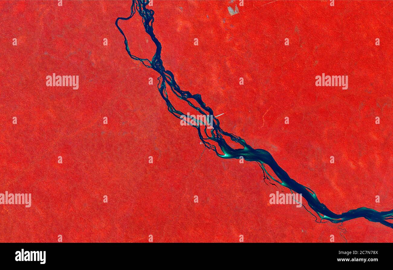 False-color composition satellite image showing the tropical forest in red, the river in blue and the clouds in white. data sentinel. Stock Photo