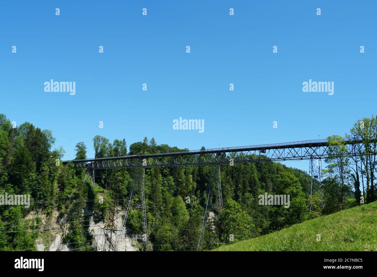 A suspension bridge joining two hills separated by a ravine or abbys on St. Gallen Bridge hiking trail in Eastern Switzerland. Stock Photo