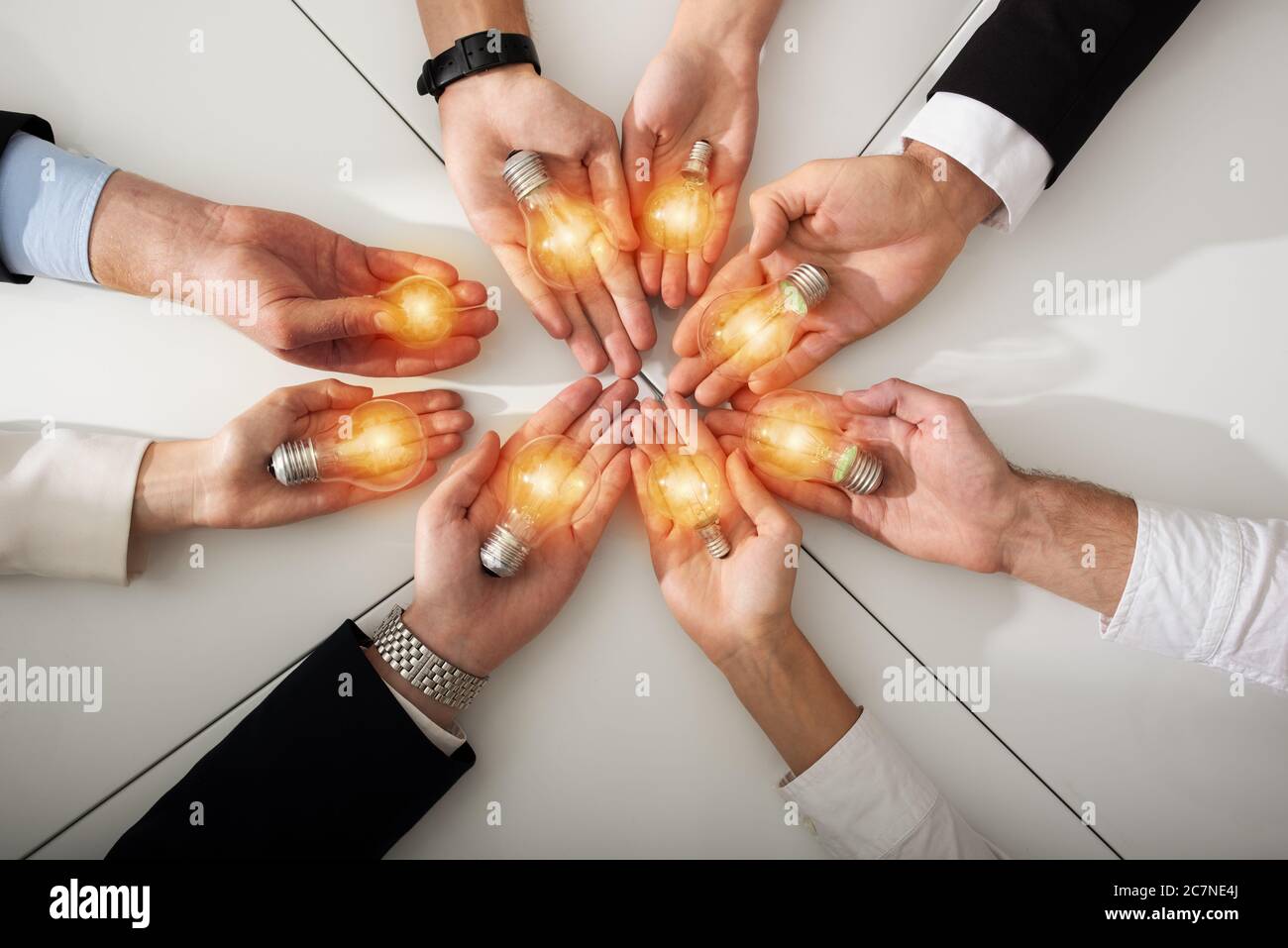 Teamwork and brainstorming concept with businessmen that share an idea with a lamp. Concept of startup Stock Photo