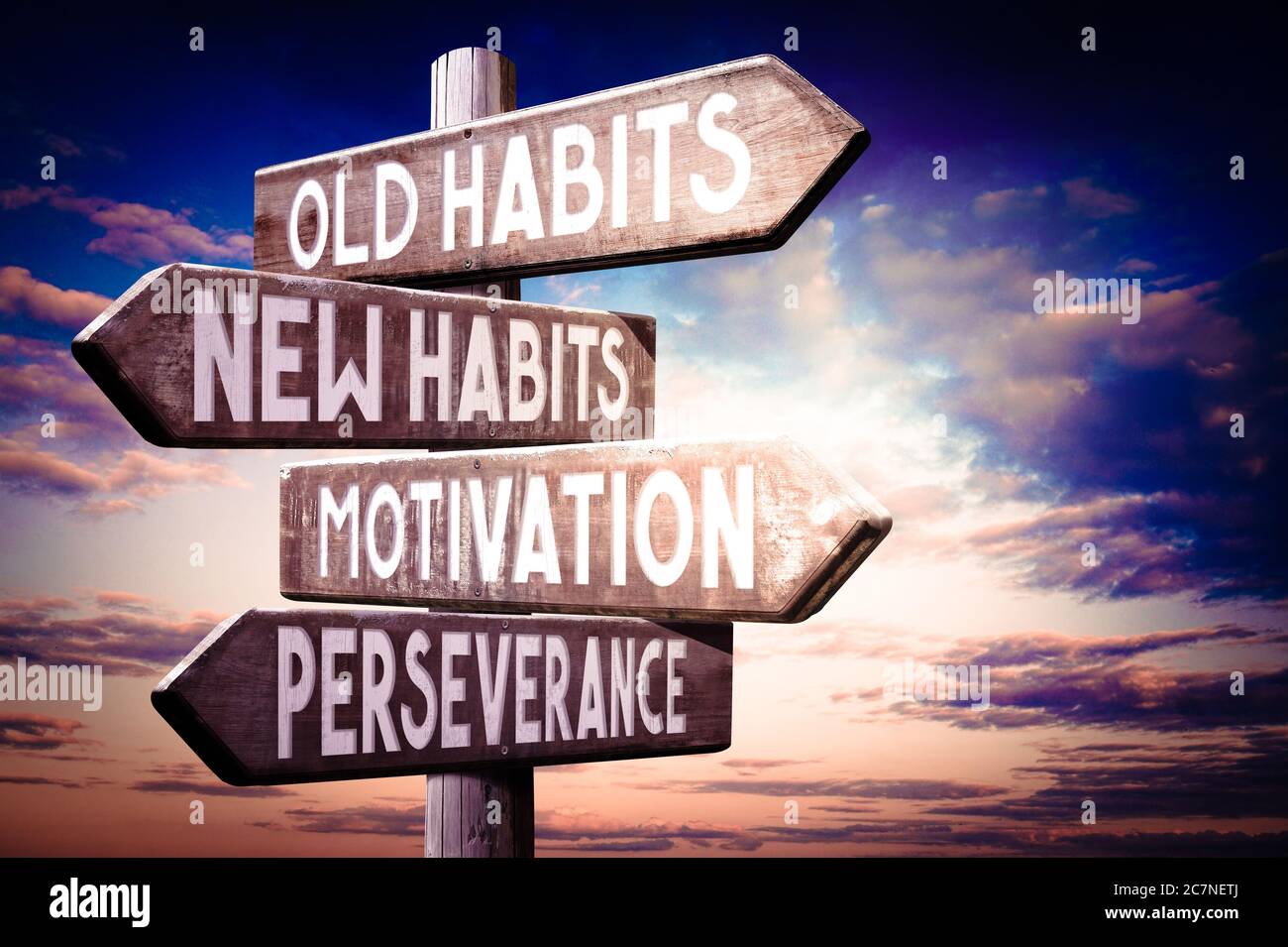 Old habits, new habits, motivation, perseverance - wooden signpost, roadsign with four arrows Stock Photo