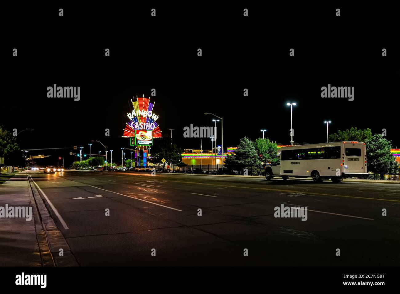Wendover, USA - July 27, 2019: Nevada city near Utah border with Rainbow Casino on road at night illuminated neon lights and shuttle bus on boulevard Stock Photo