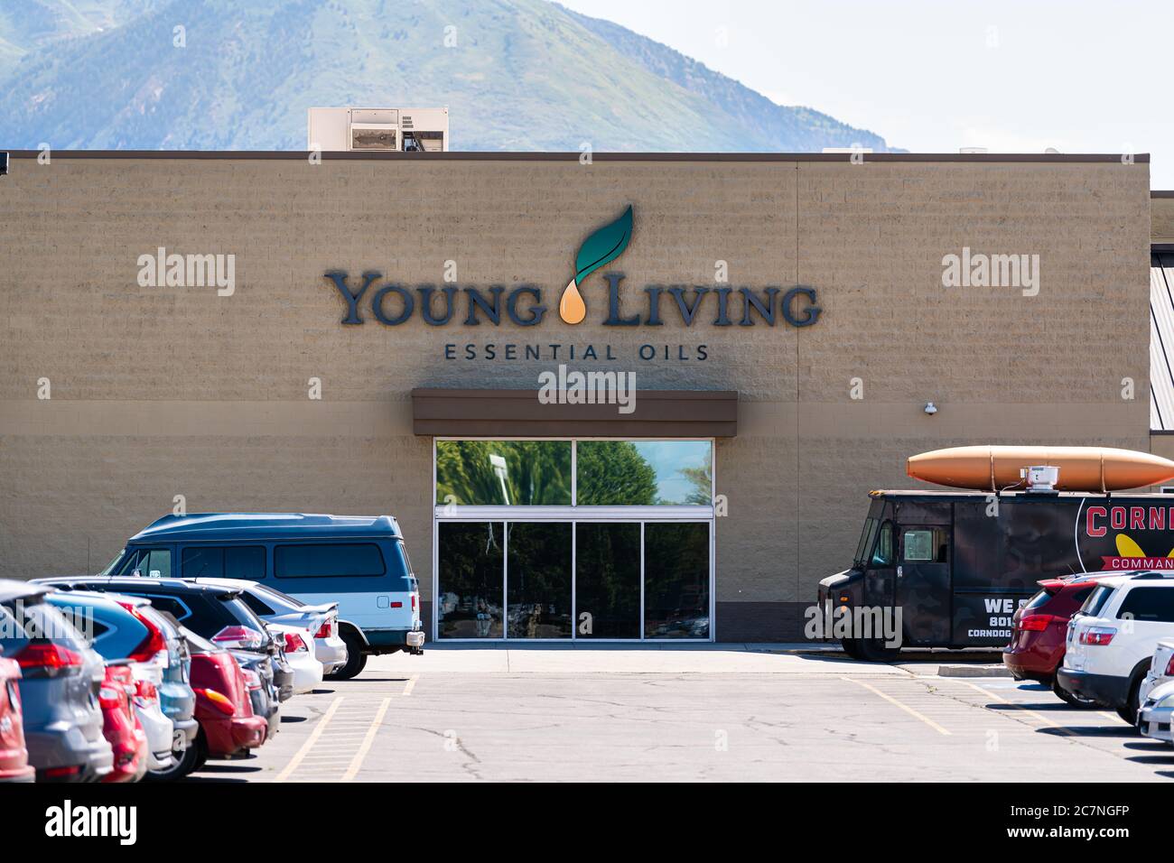 American Fork, USA - July 29, 2019: Young Living Essential Oils Member Services headquarters company warehouse in Utah with parking lot cars by sign e Stock Photo
