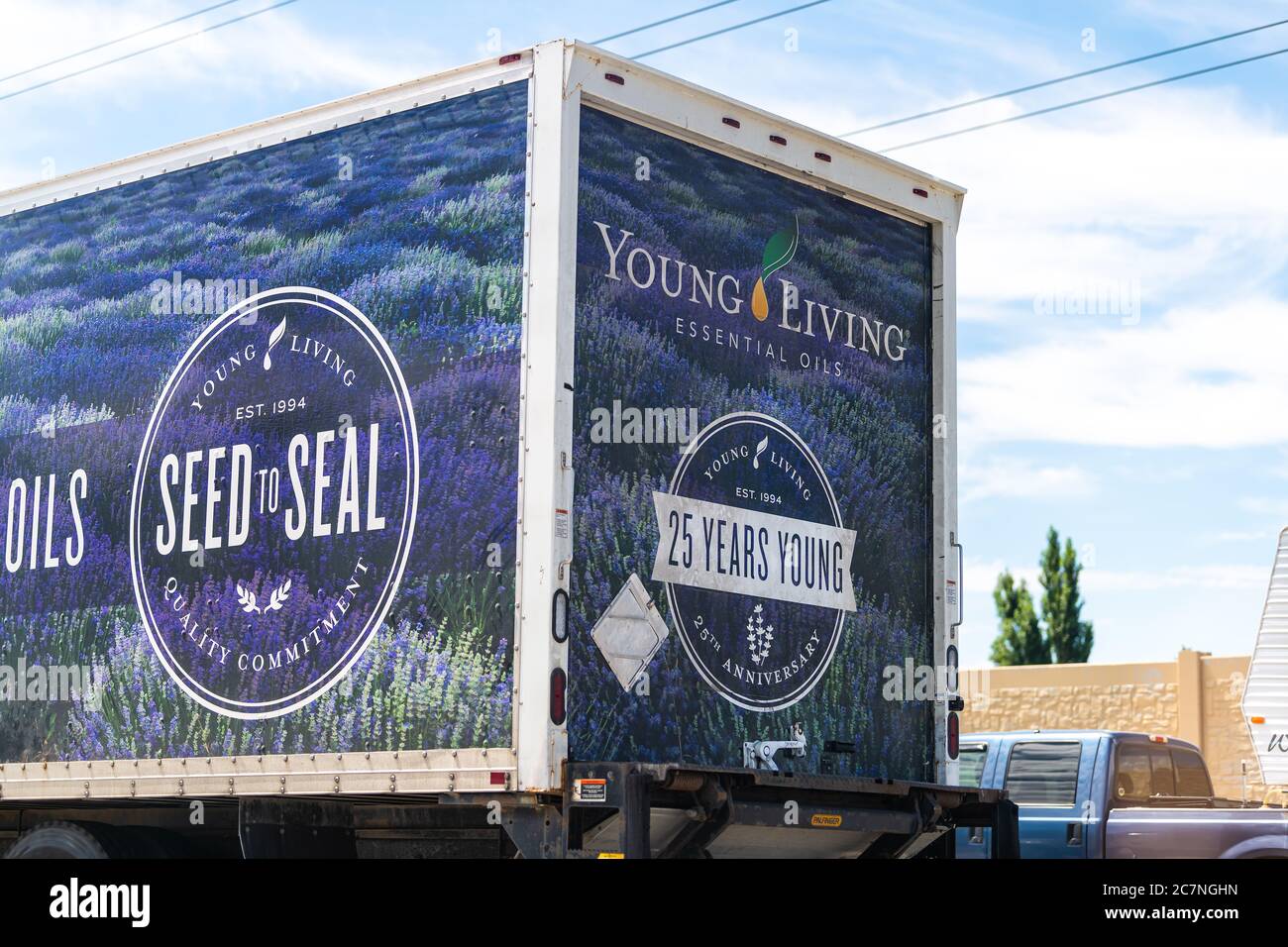 American Fork, USA - July 29, 2019: Sign for Young Living Essential Oils company delivery truck near warehouse on highway road in Utah cars in traffic Stock Photo