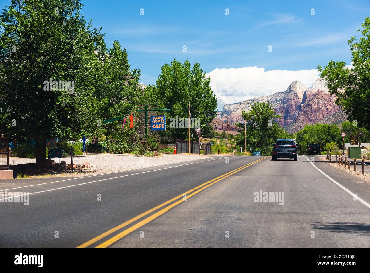 Springdale, USA - August 5, 2019: Zion National Park road in Utah and cars in road traffic point of view driving in city with restaurant shop stores s Stock Photo