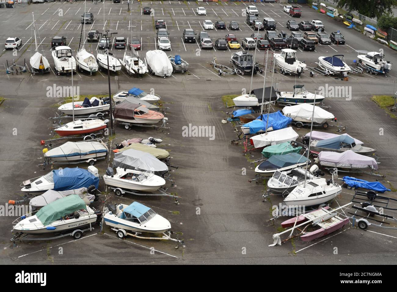 Various sailing and power boats are stored in a car parking lot below the Burrard Street Bridge in Vancouver, British Columbia, Canada Stock Photo