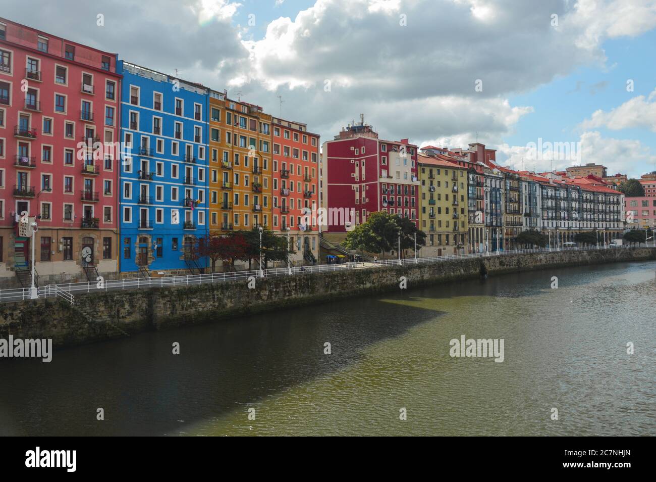 Colored buildings over river in Bilbao city in summer, Spain Stock ...