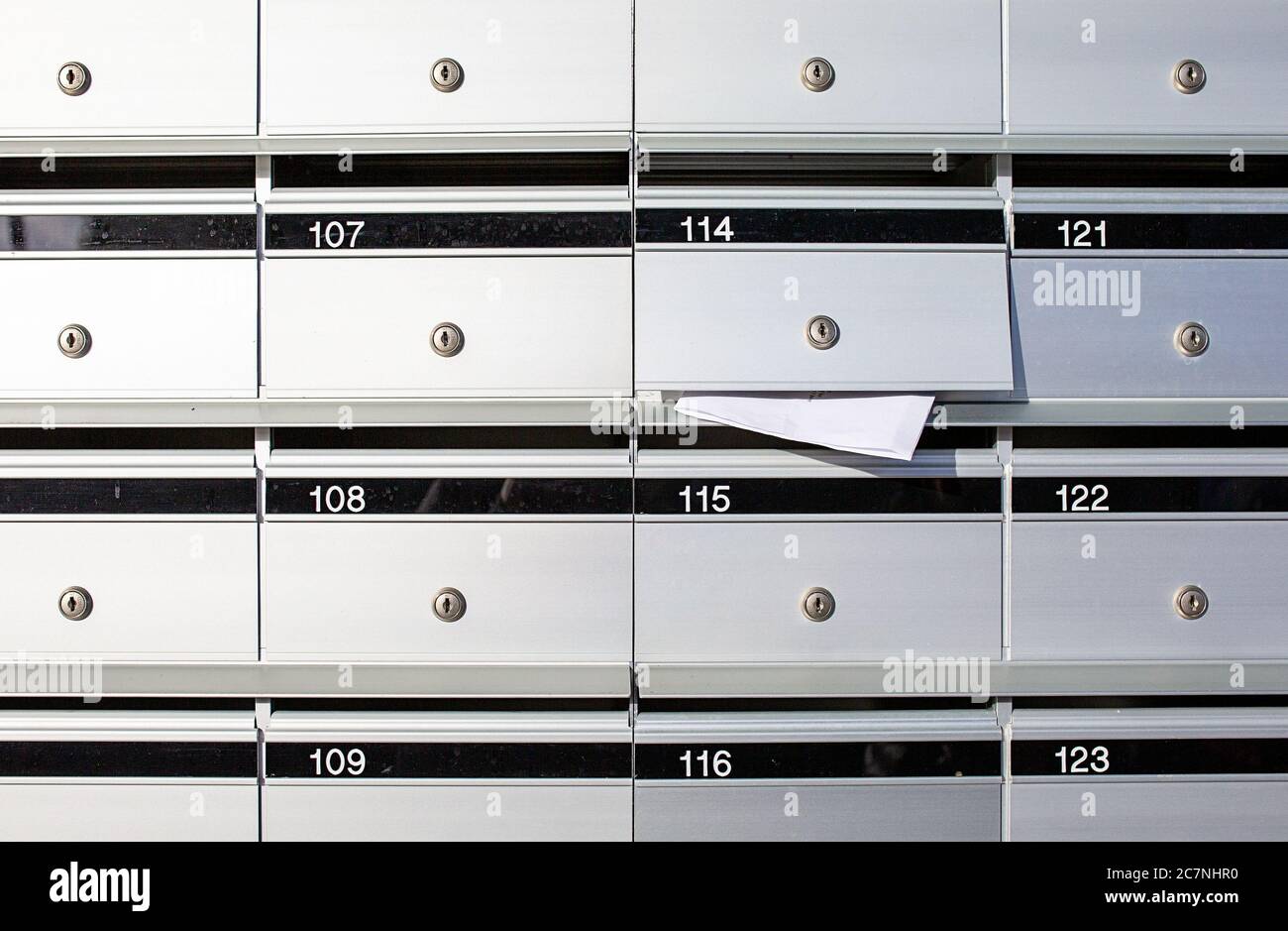 Letterboxes for apartments, with mail sticking out of one Stock Photo