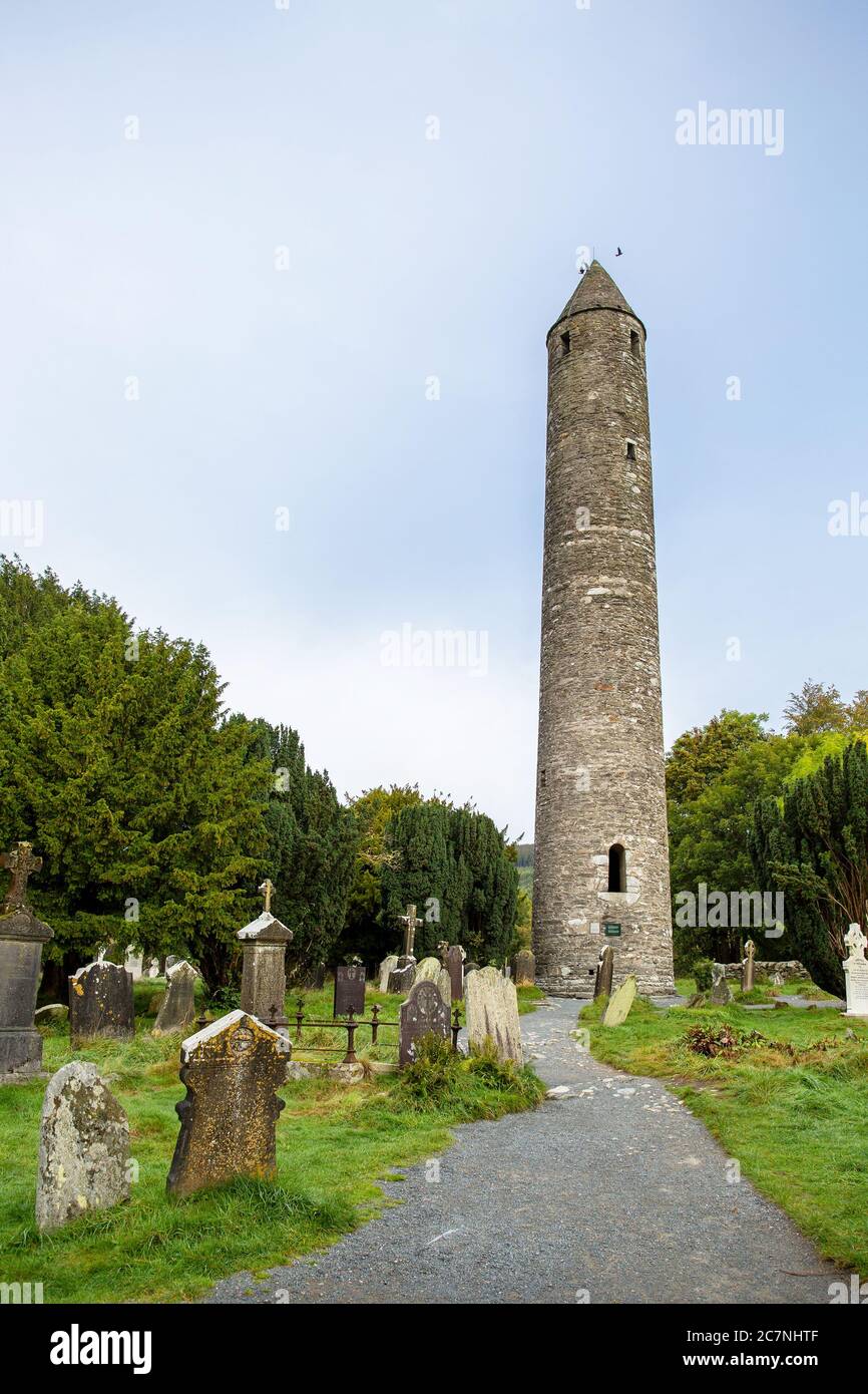The Round Tower at Glendalough with graveyard in the foreground Stock Photo