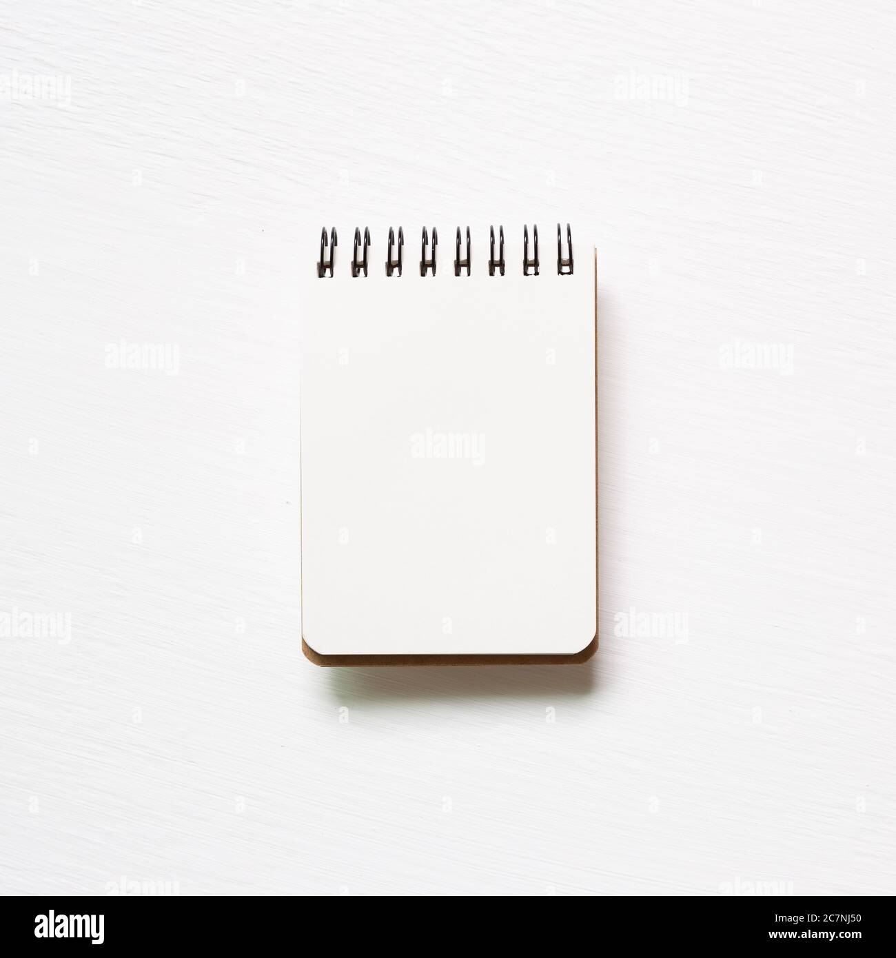 Empty spiral notebook on white painted background. top view, copy space Stock Photo