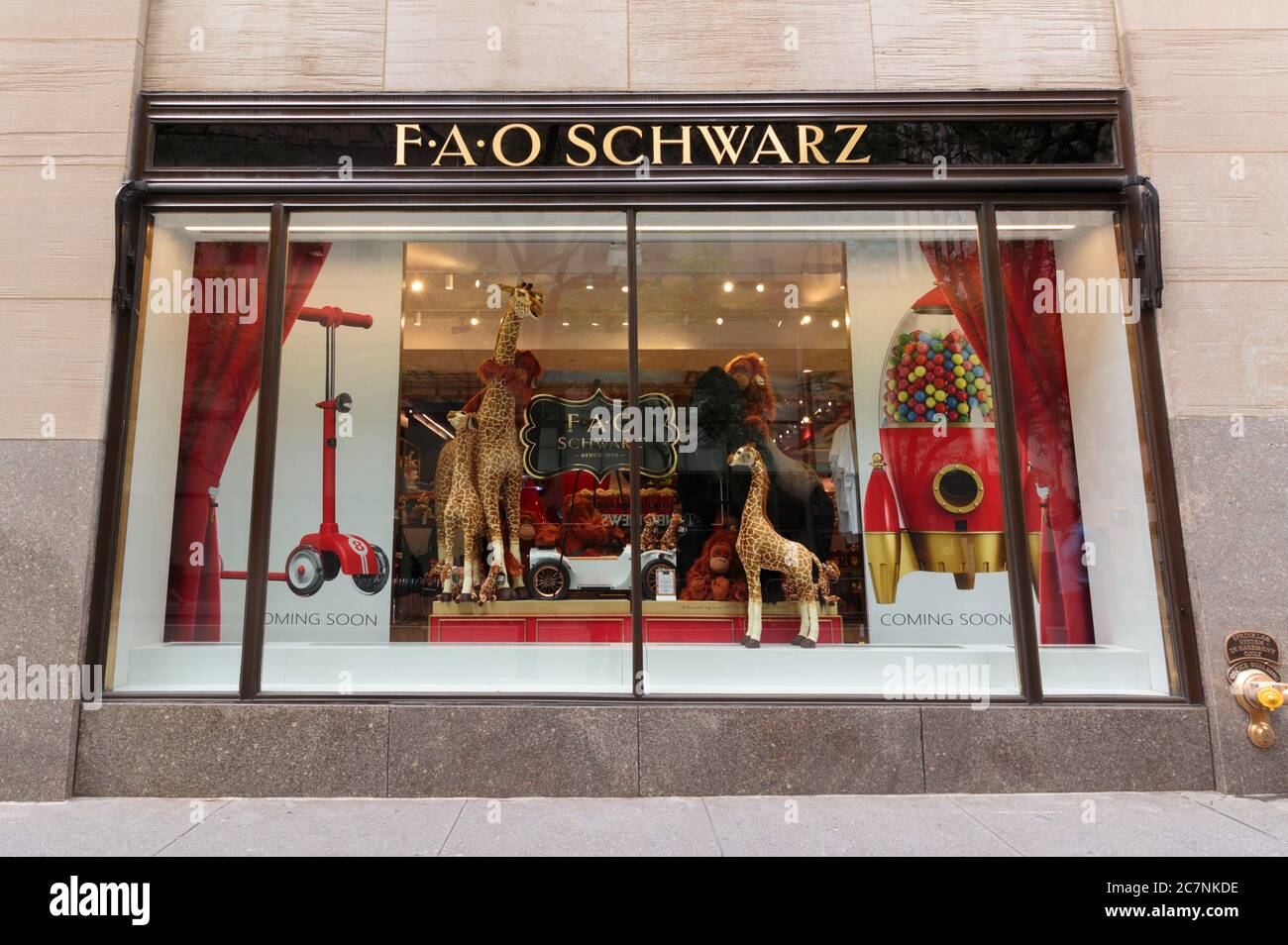 store window of the FAO Schwartz luxury toy store in Rockefeller Center displaying oversized stuffed giraffes and other animals Stock Photo