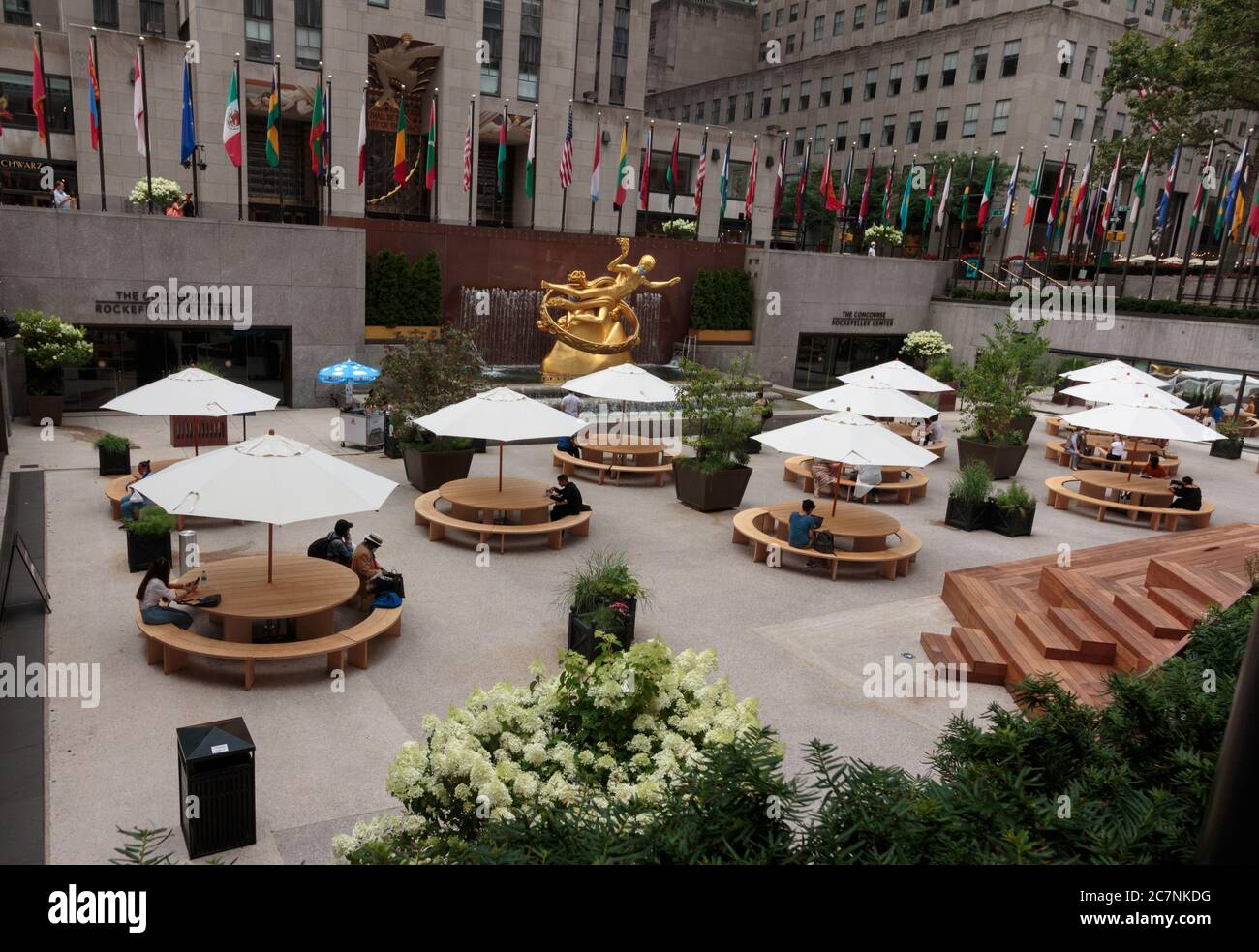 scene at the concourse of the Rockefeller Center during the coronavirus or covid-19 pandemic, with very few people sitting and social distancing Stock Photo
