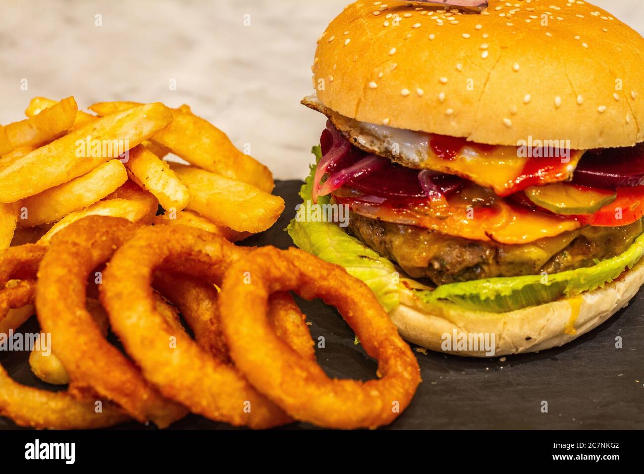 Beef burger with chips onion rings and fries Stock Photo Alamy
