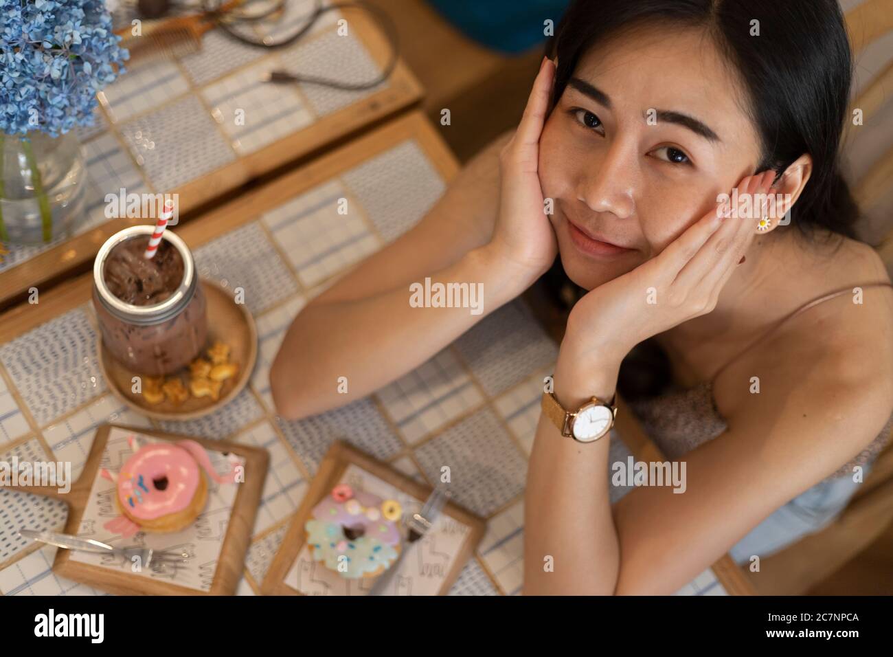 Top view young girl with  donut and beverage at a cafeteria. Stock Photo