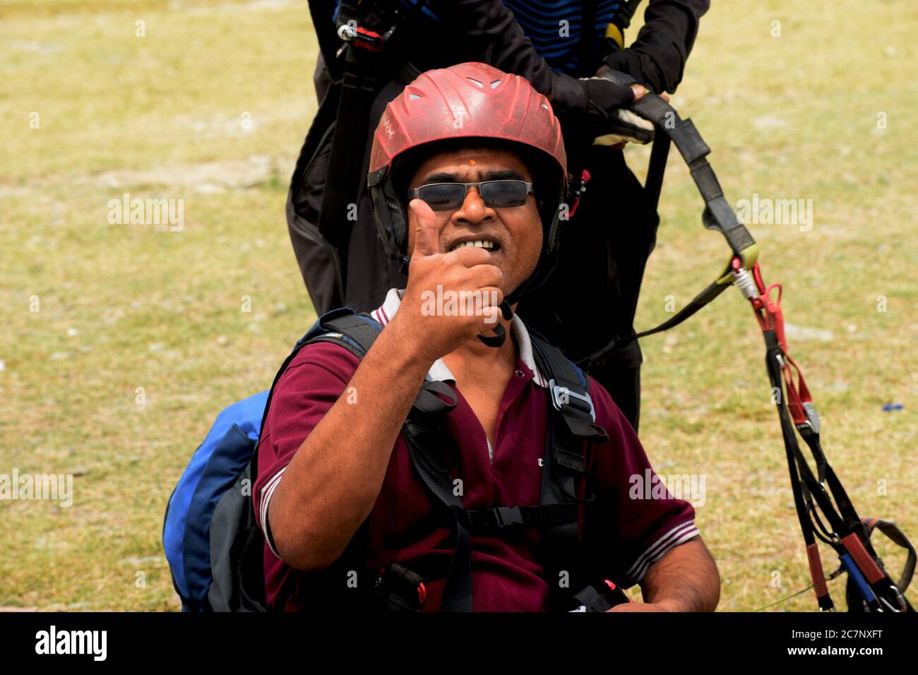An Indian para glider showing thumps up after landing  in Naukuchia Taal in Nanital, Selective focusing Stock Photo
