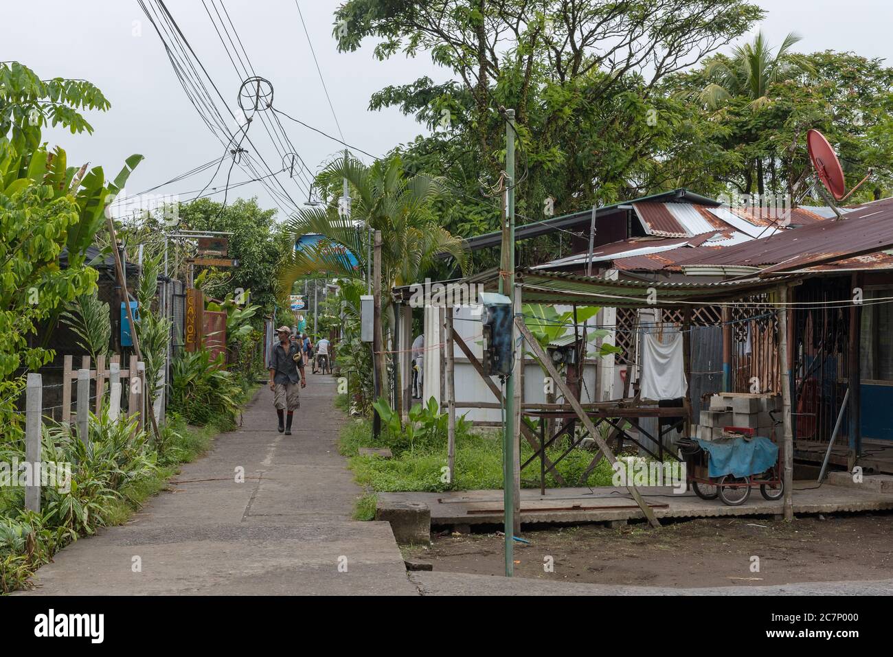Footpath with unidentified people in the Tortuguero village in rainy weather, Costa Rica Stock Photo