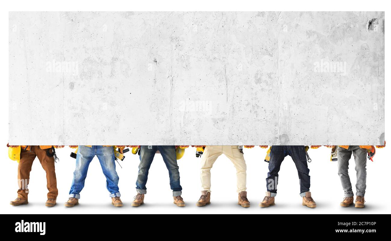 Builders with tools in construction clothing hold a heavy slab Stock