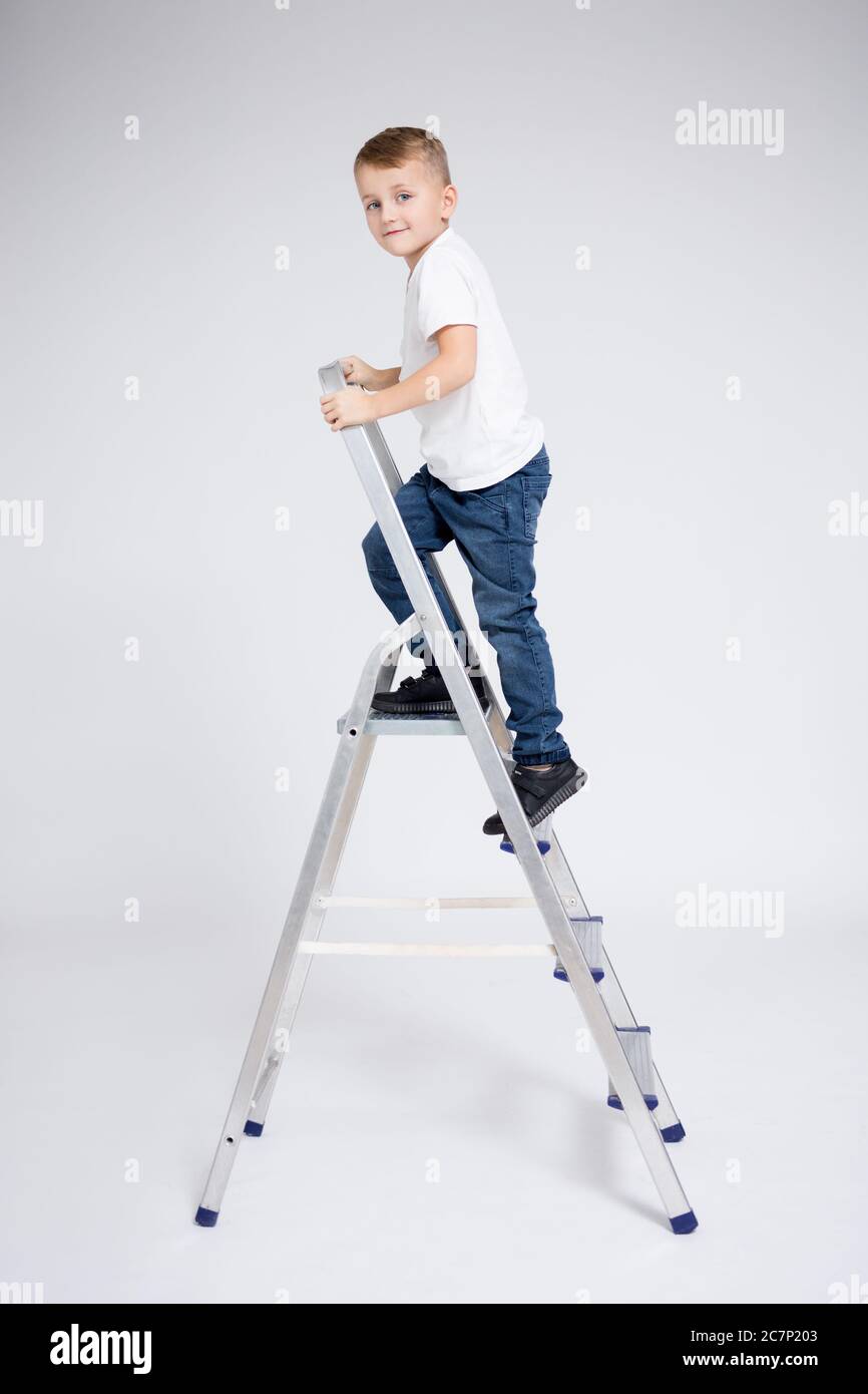 success, education and career concept little boy on stepladder over