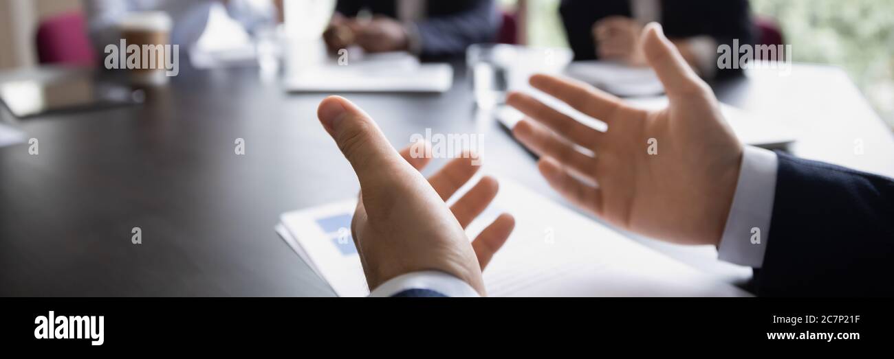 Project leader gesticulate hands while talking during meeting, close up Stock Photo