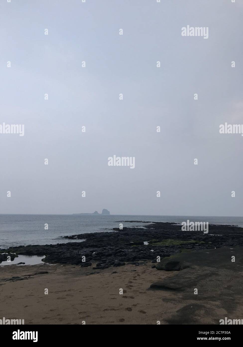 Vertical shot of a rocky shore on a foggy day Stock Photo - Alamy