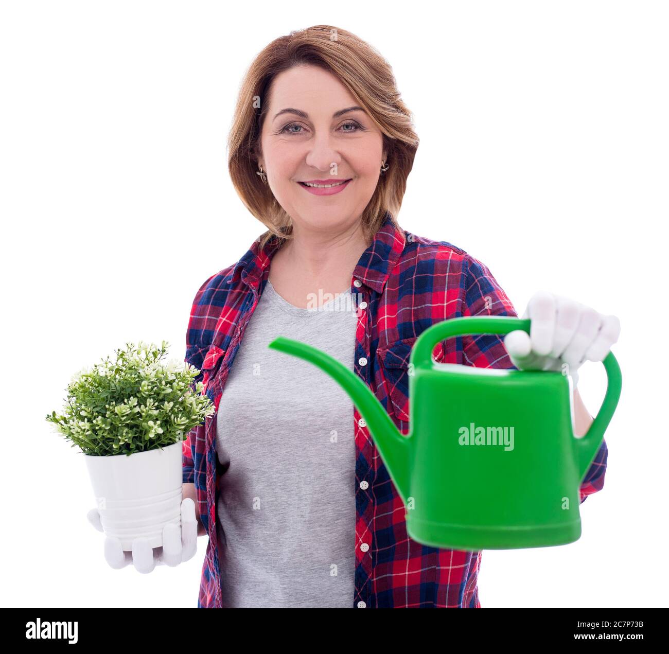 portrait of smiling mature woman gardener with watering can and potted ...