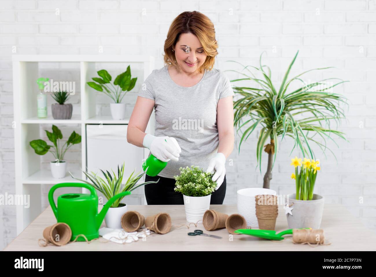 spring concept - portrait of mature female gardener planting flowers in ...