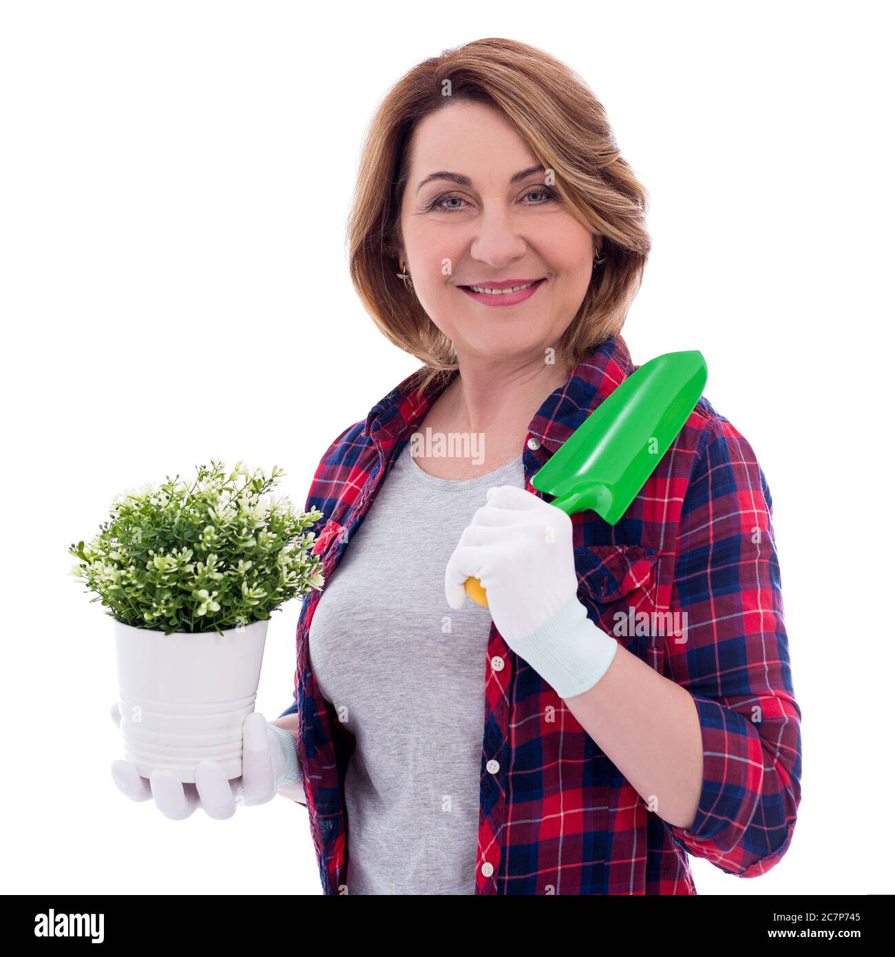 portrait of smiling mature woman with potted plant and small shovel ...