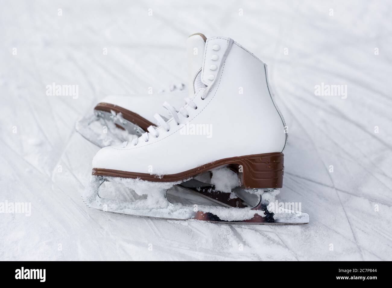 close up of figure skates over ice background with marks from skating Stock Photo