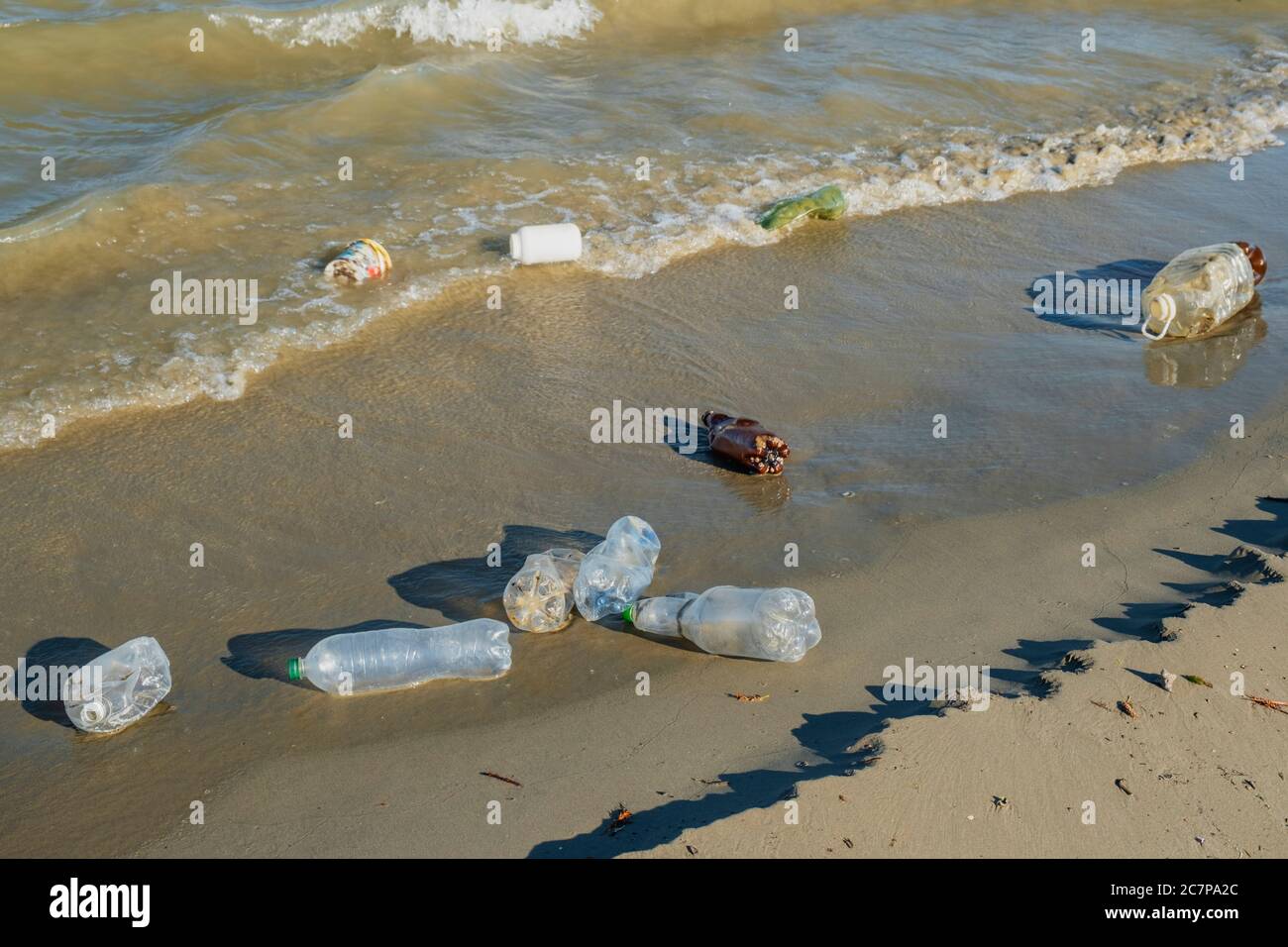 Washed by the waves ashore plastic bottles. Massive plastic pollution on the Danube river bank in Danube Biosphere Reserve. Plastic garbage environmental pollution problem. Plastic and other garbage from all over Europe is washed out by the Danube river into the Black Sea. Stock Photo
