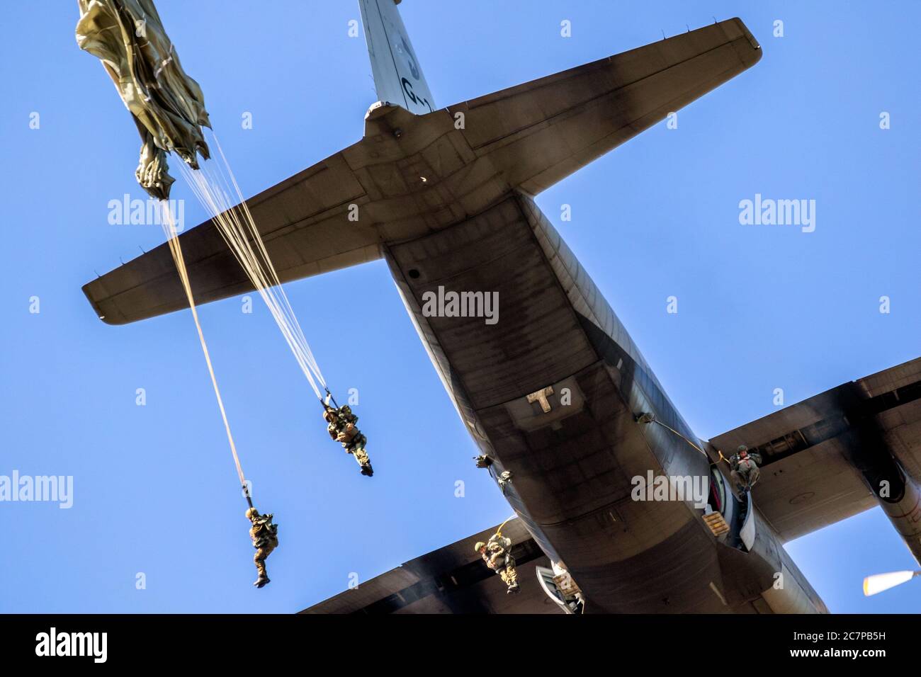 EDE, NETHERLANDS - SEP 21, 2019: Military paratroopers parachute jumping out of a Air Force C-130 Hercules transport plane during the Operation Market Stock Photo