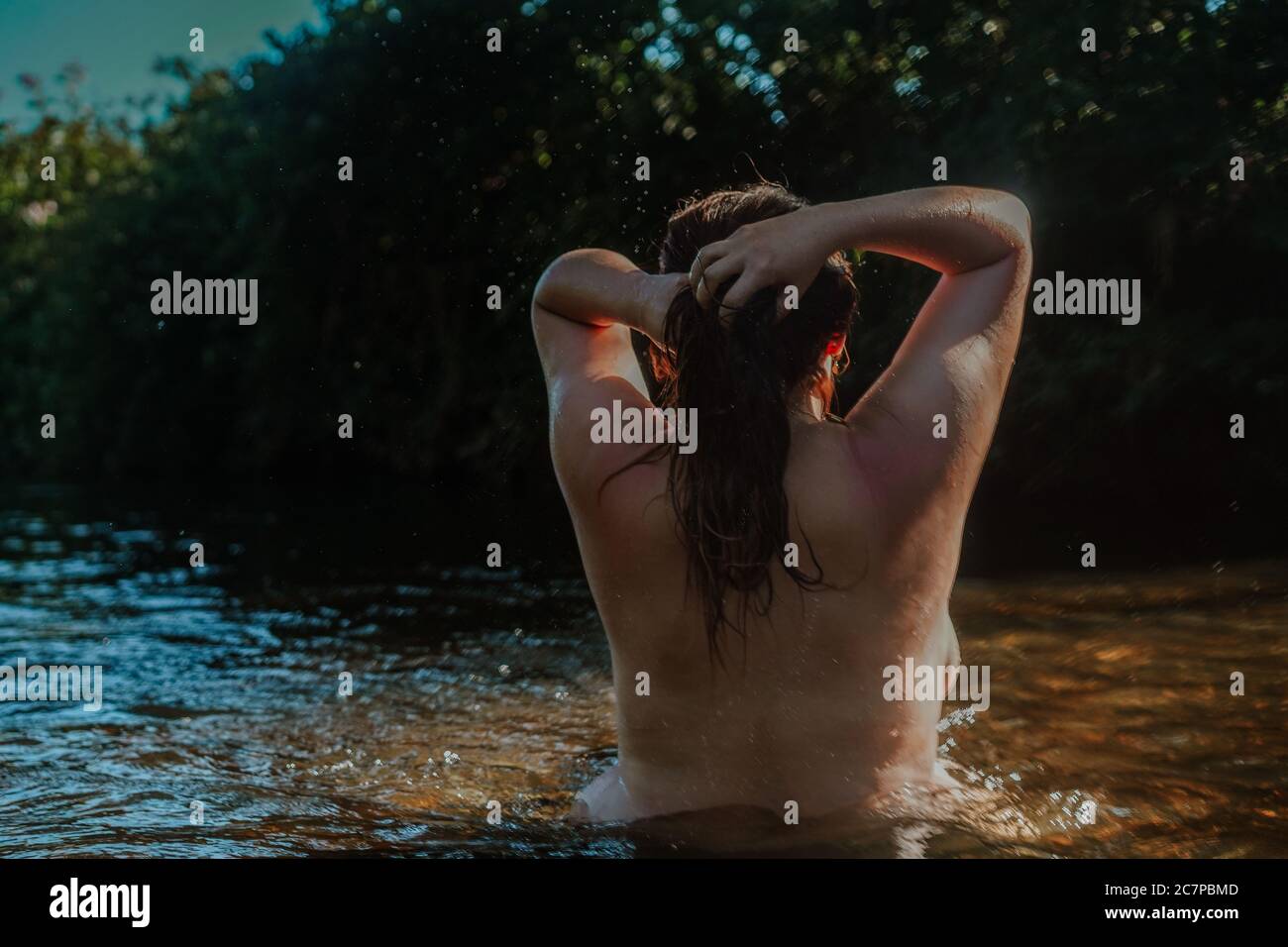 Beautiful woman skinny dipping and wild swimming in river Stock Photo -  Alamy