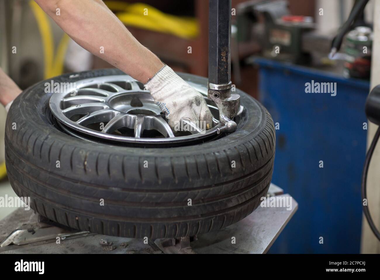 Mechanic changing car tire fitting. Wheel tyre repairing Stock Photo